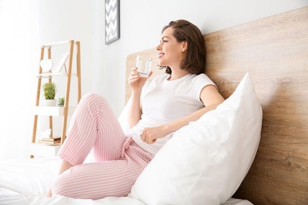 Woman Happy at Home as she Drinks Filtered Water
