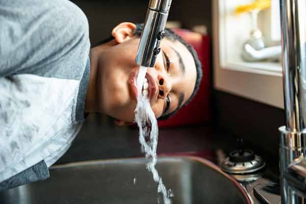 Lead Pipes in Homes Photo of Child Drinking From Faucet