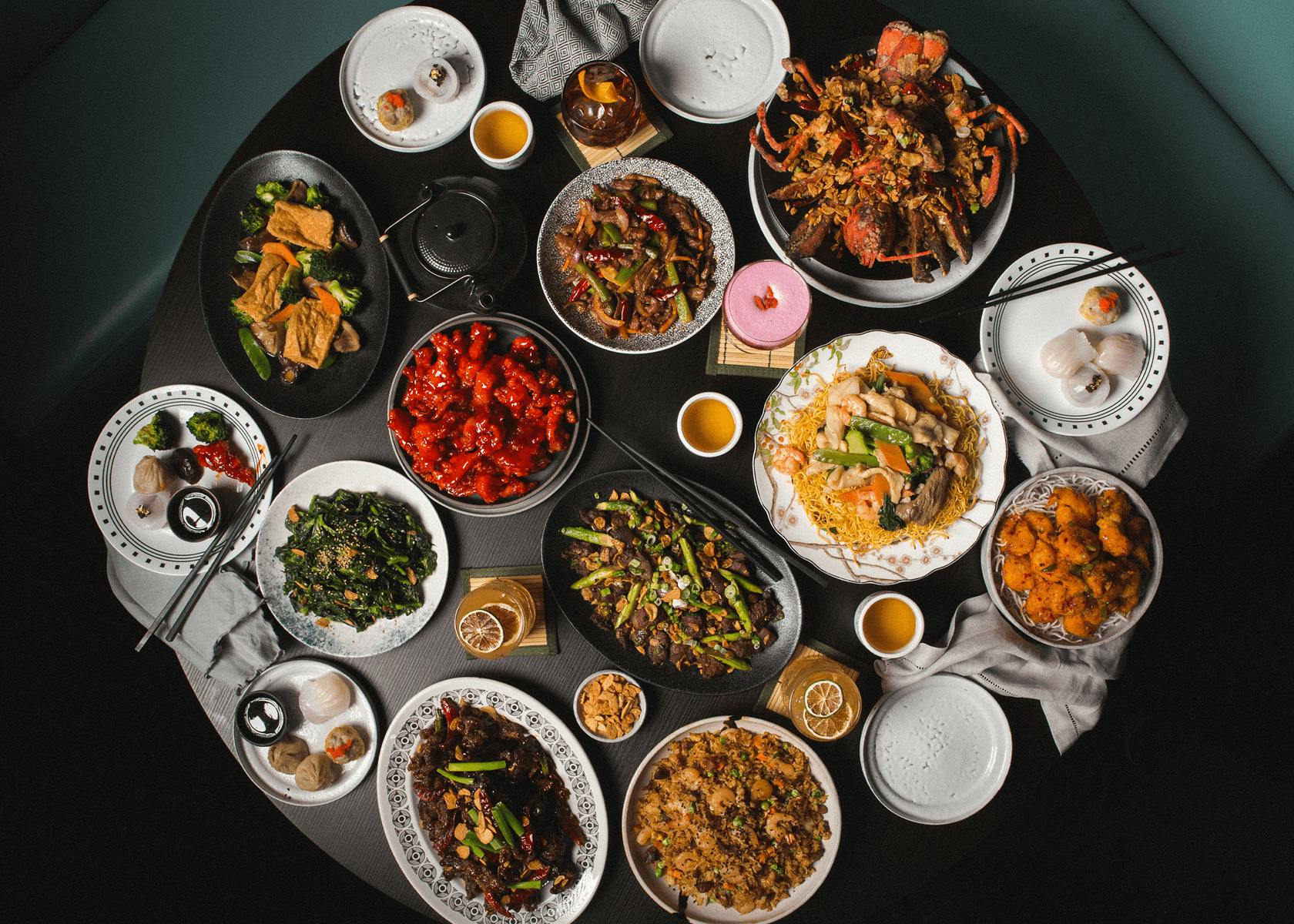 Spread of a variety of meals displayed nicely on a black table. | Hong Shing Toronto
