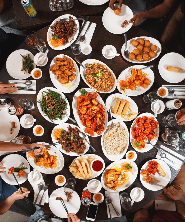 Assortment of plates of Hong Shing food on table.