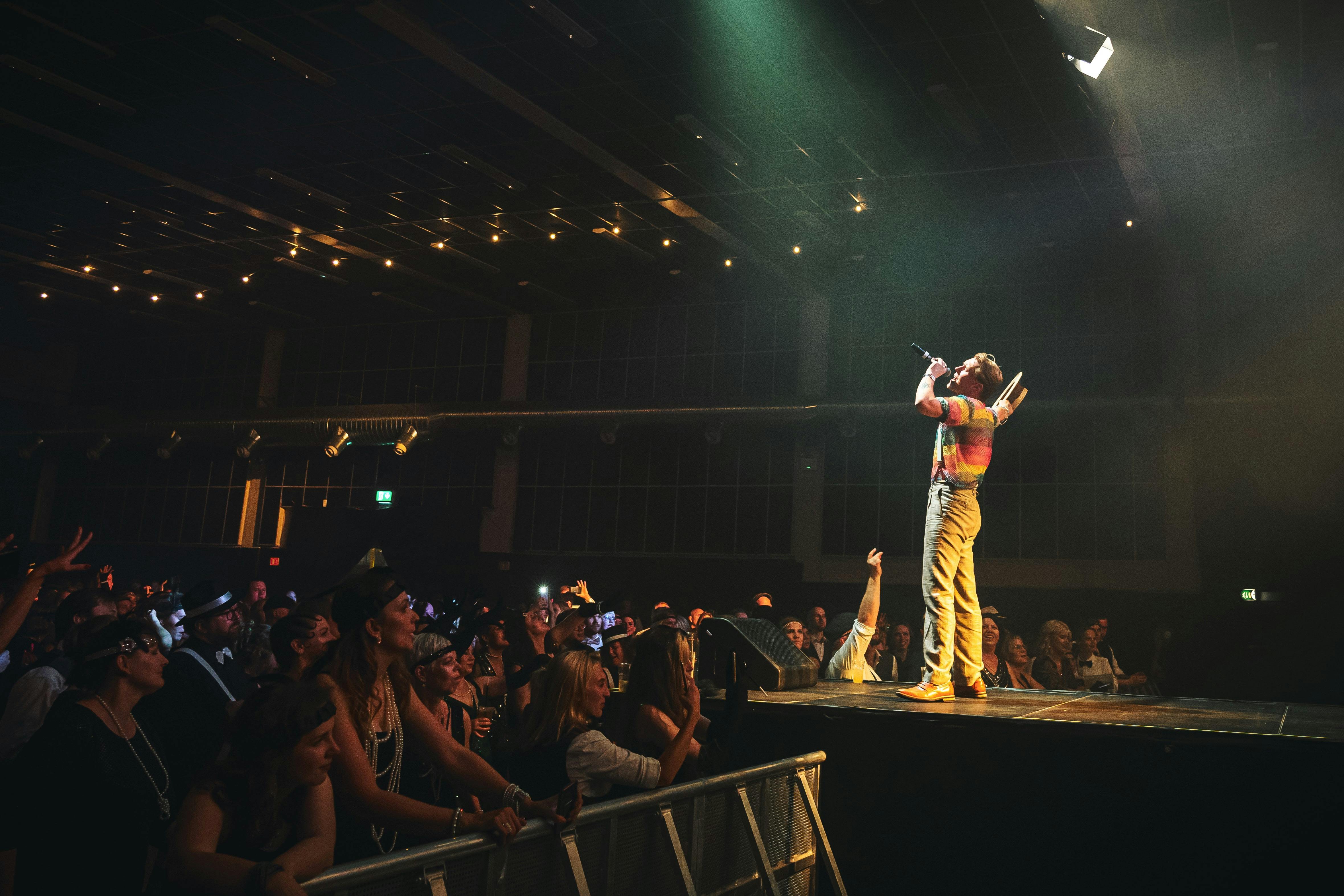 Bilde av artist på en scene med publikum foran, tatt fra scenen, for å illustrere hvor enkelt det er å selge konsertbilletter med Hoopla