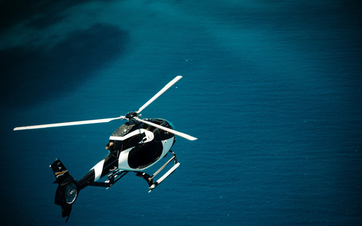 Black and white helicopter flying over Seychelles