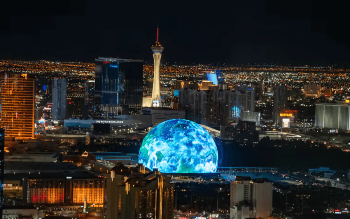 Las Vegas Sphere and Strat Hotel behind, at night from helicopter