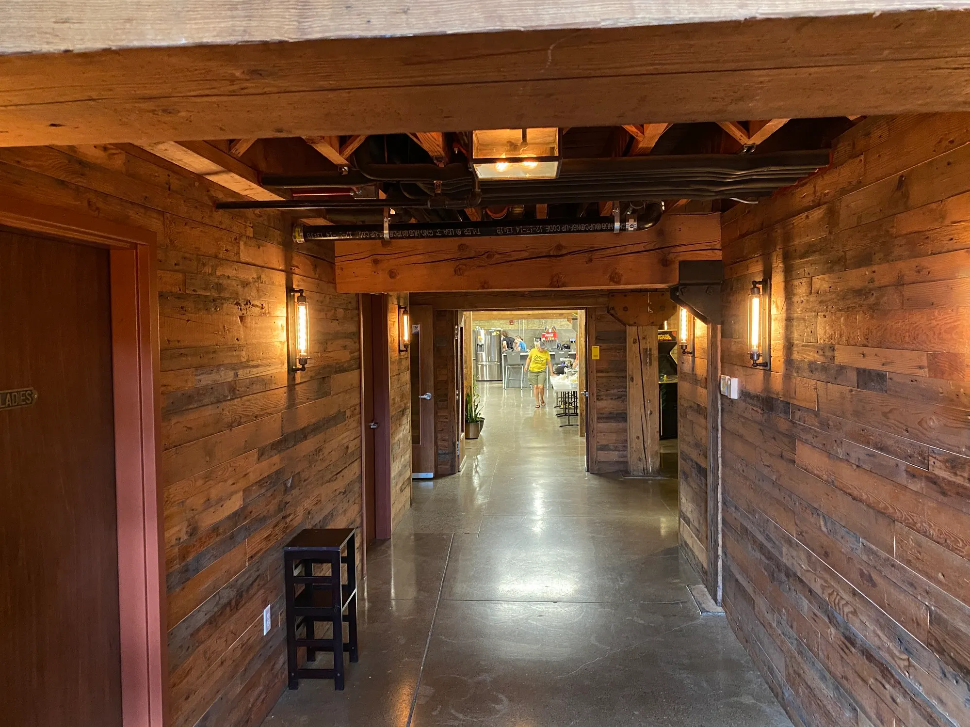 Hallway with reclaimed wood walls and exposed timber beams inside the Meadowlark Building