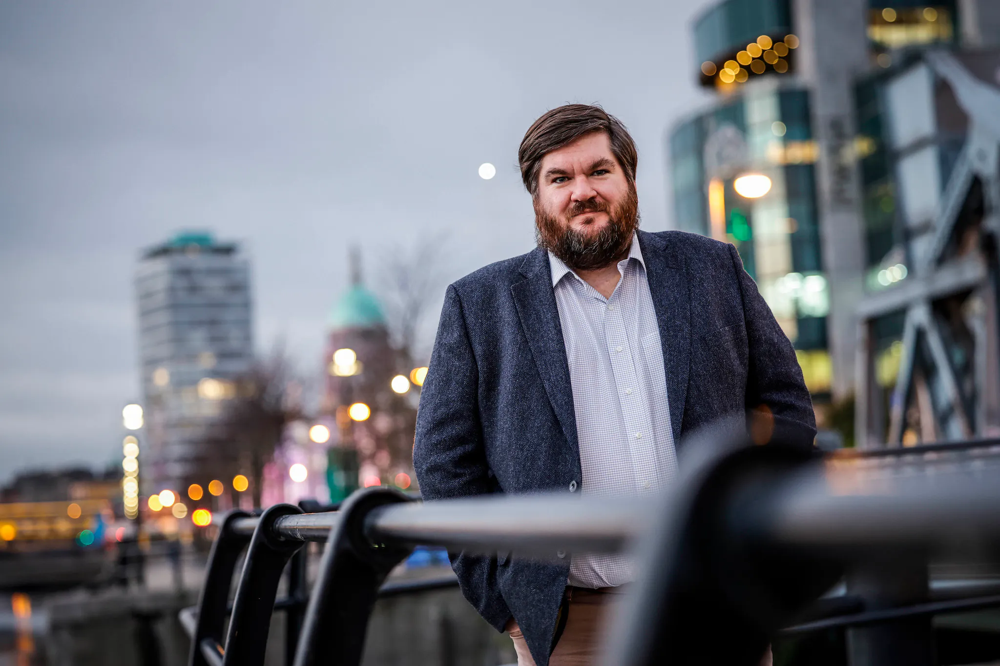 CEO Dr Joe Fitzsimons stands on a bridge over Dublin's Liffey River