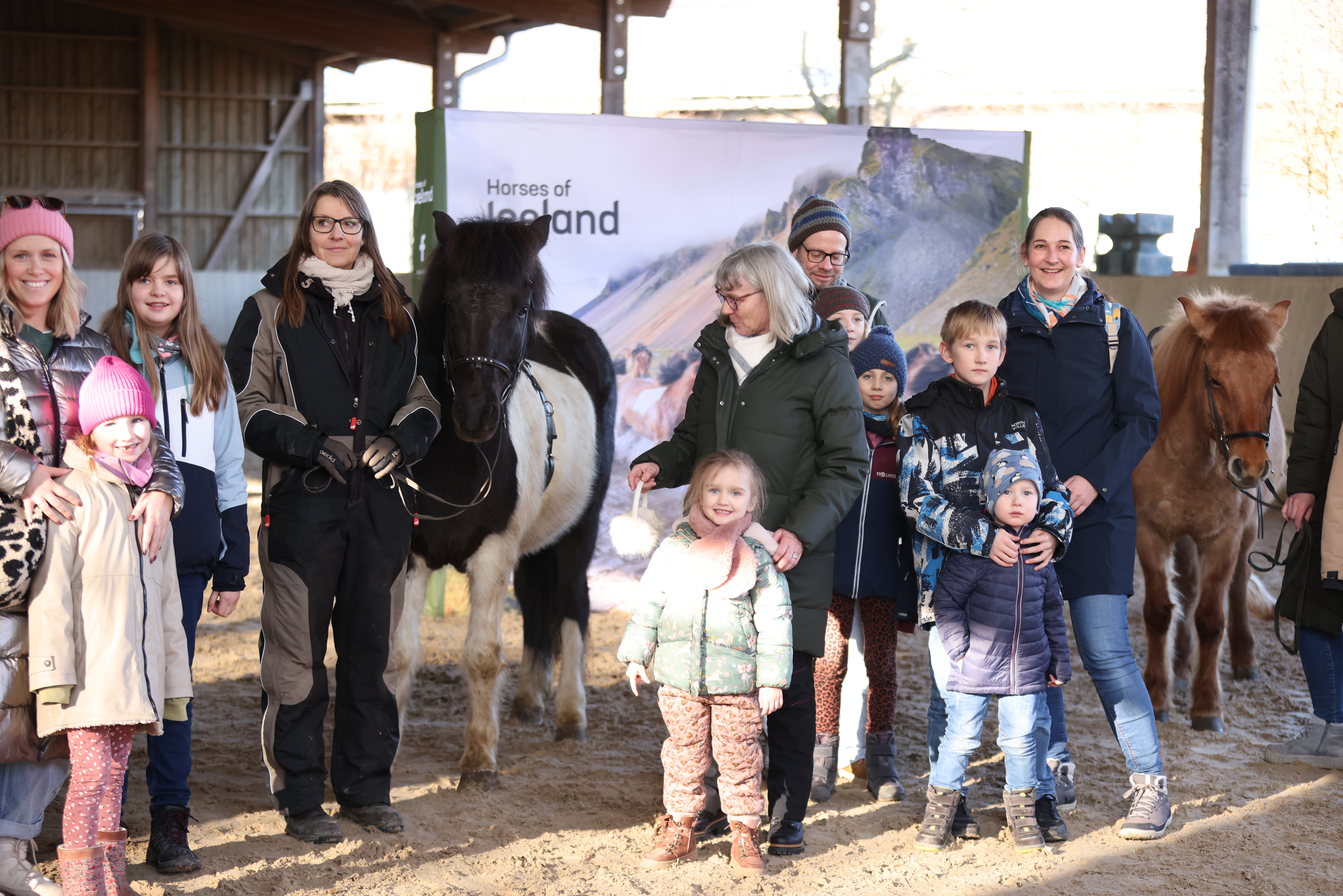 Adults and children pose around Icelandic horses in Germany