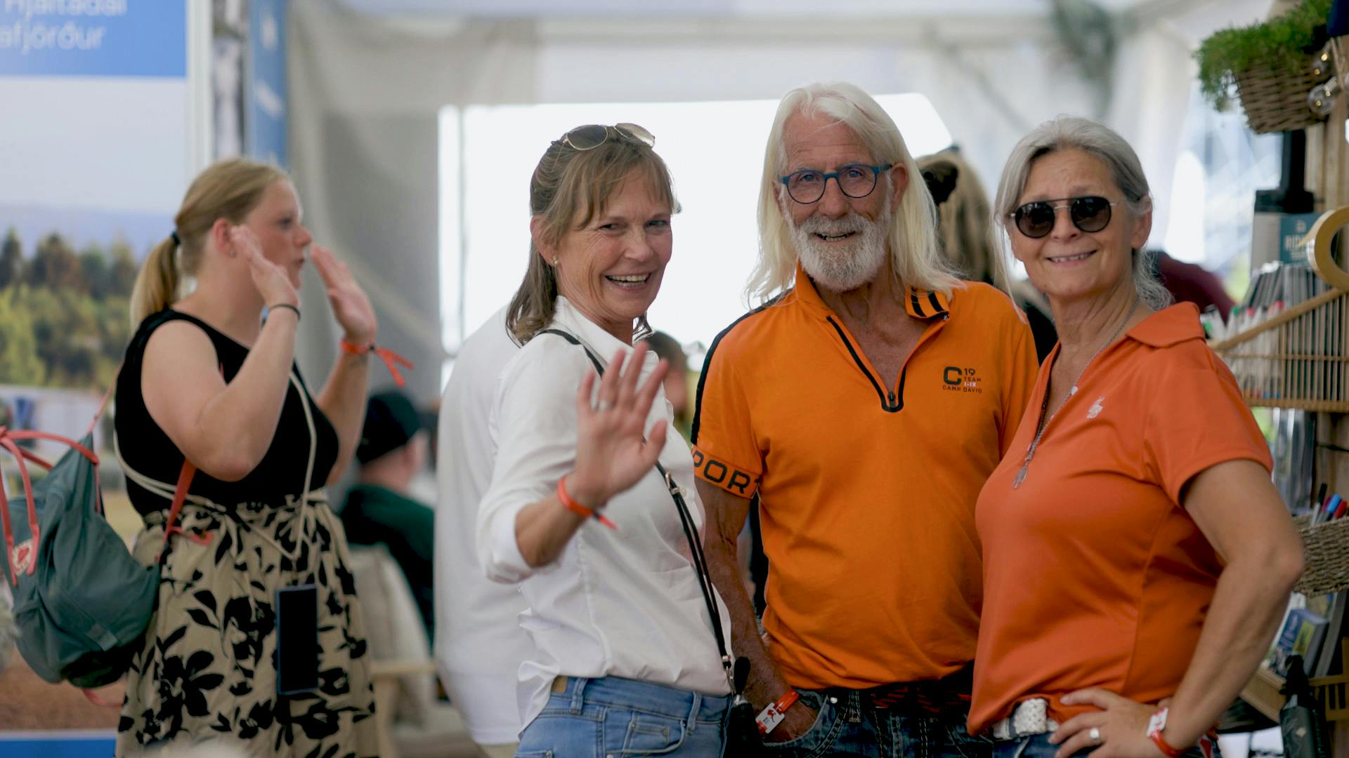 Stand visitors wave and smile at the camera on the Horses of Iceland stand
