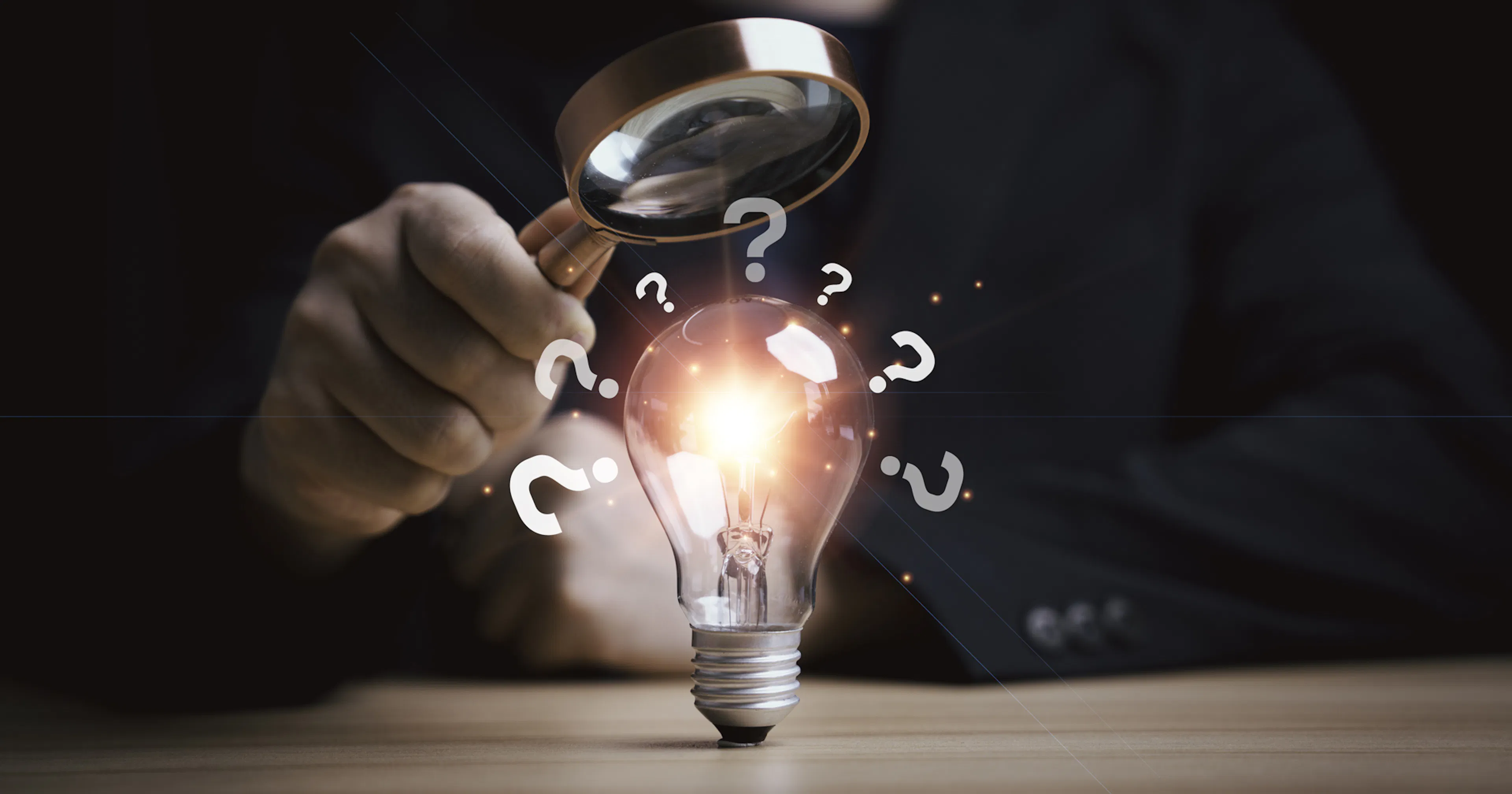 Man holding a magnifying glass to a lightbulb