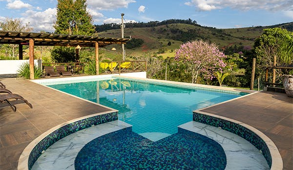 Vista panorâmica de piscina da pousada mata que canta