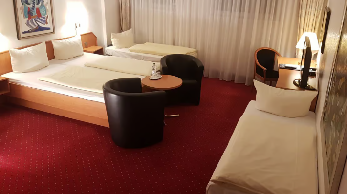 one double bed and 2 extra beds shown in a comfortable room