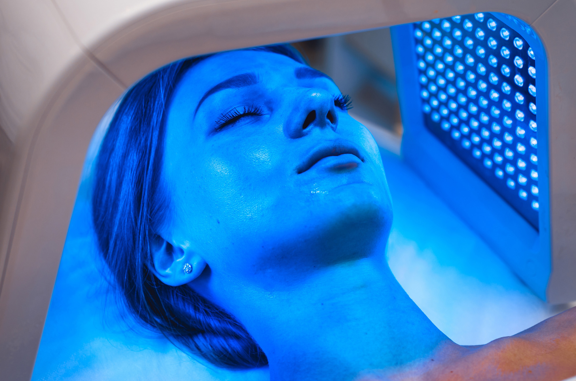 Woman receiving blue LED light therapy as part of her regenerative medicine treatment