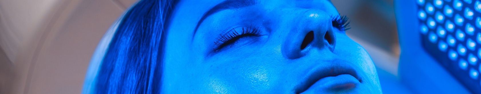 Woman receiving blue LED light therapy as part of her regenerative medicine treatment