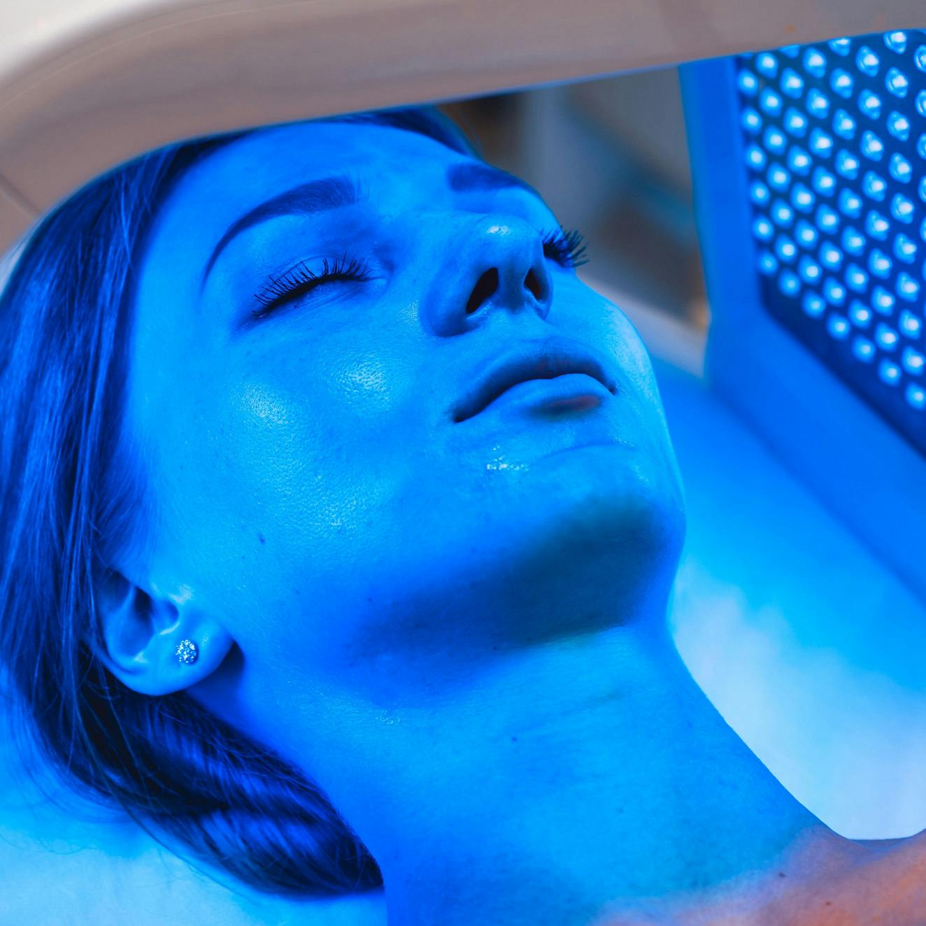 Woman receiving blue LED light therapy as part of her regenerative medicine treatment