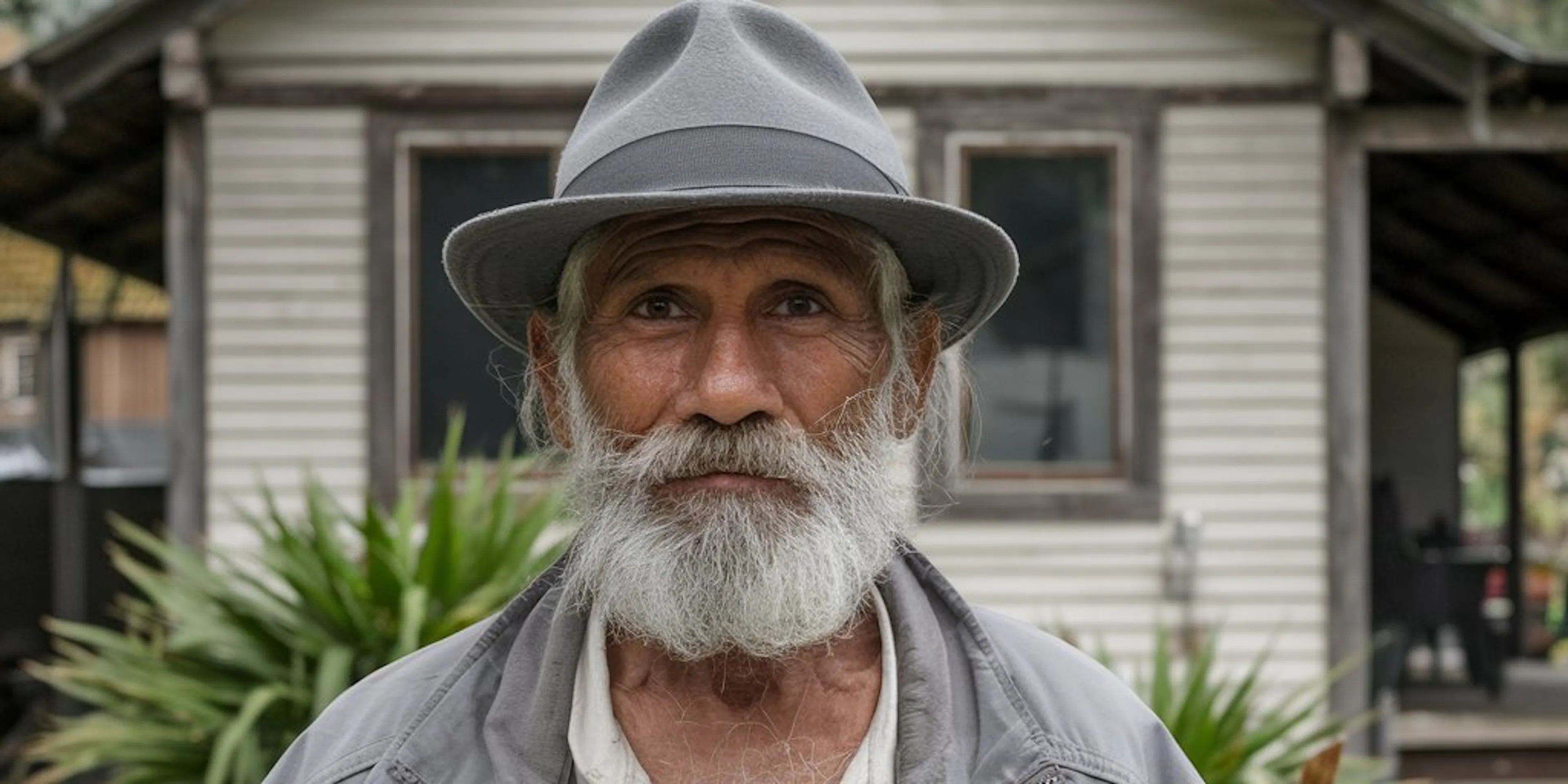 Un vieil homme devant sa maison
