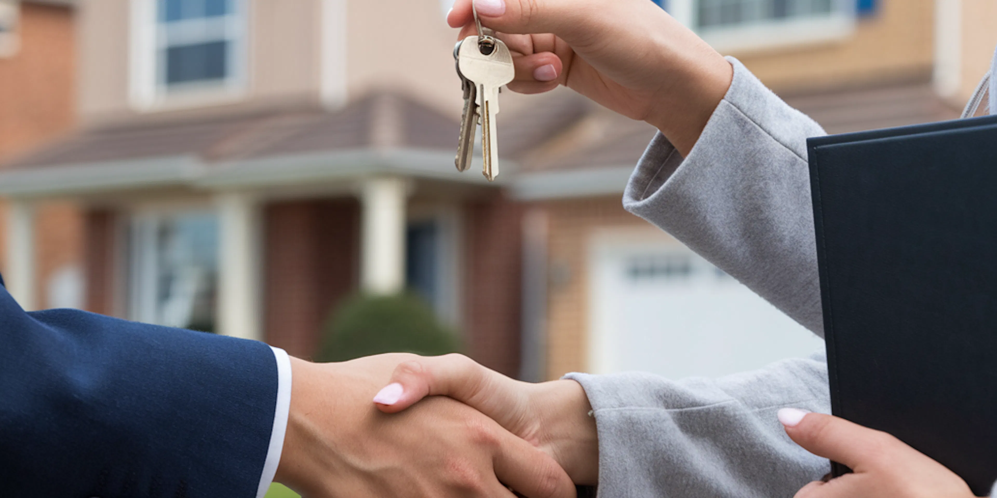 Un homme qui tend les clés d'une maison
