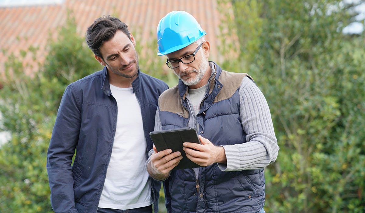 Deux hommes regardent une tablette