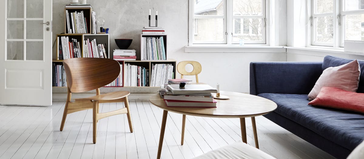 Light filled room with blue coach and simple coffee table. 