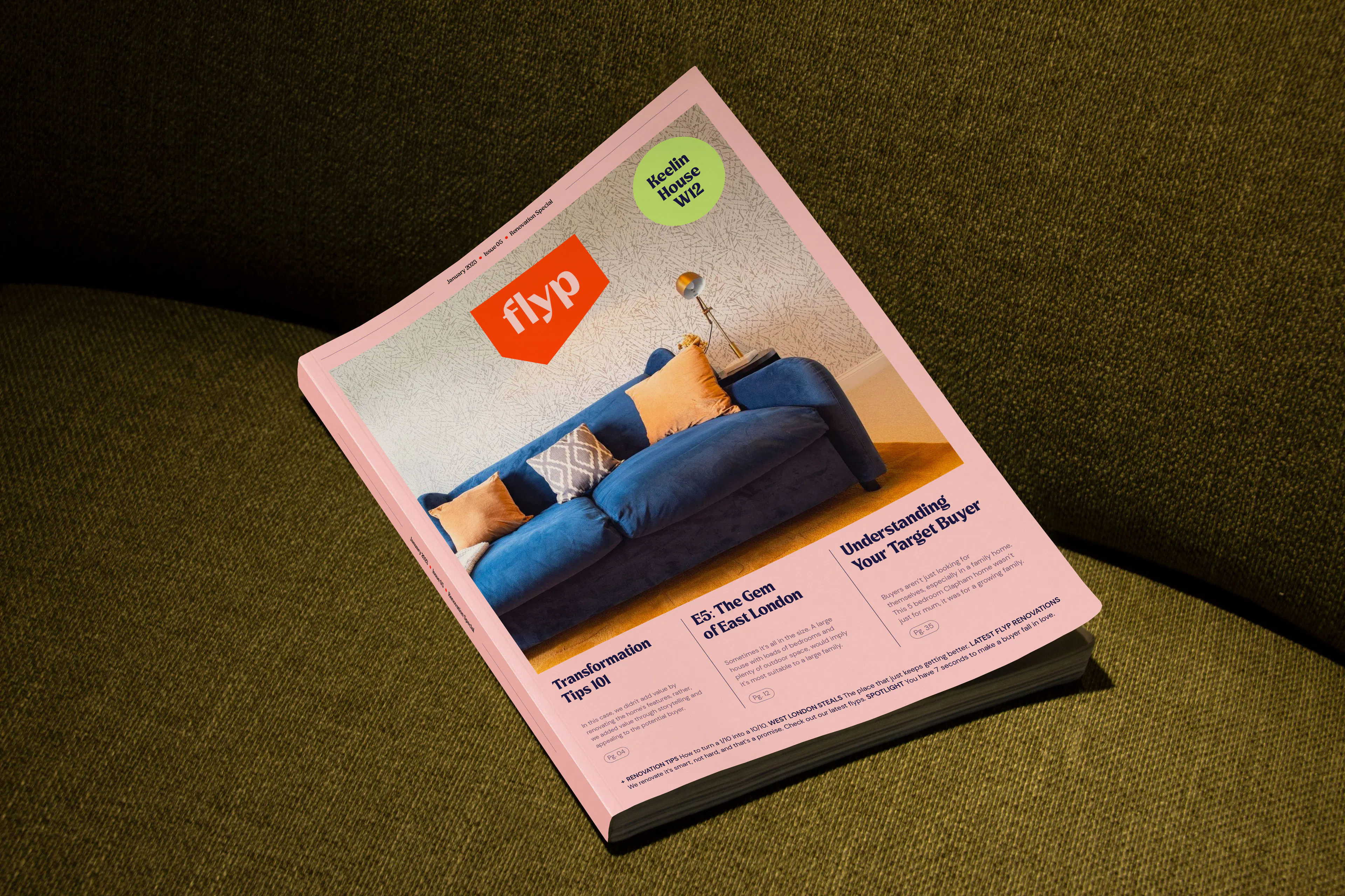flyp magazine with a blue sofa on its pink cover, lying on a green sofa