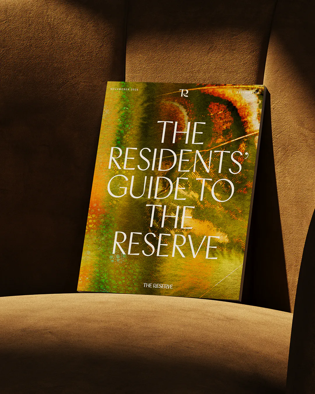 Booklet titled 'The Residents' Guide to The Reserve' propped on a velvet armchair