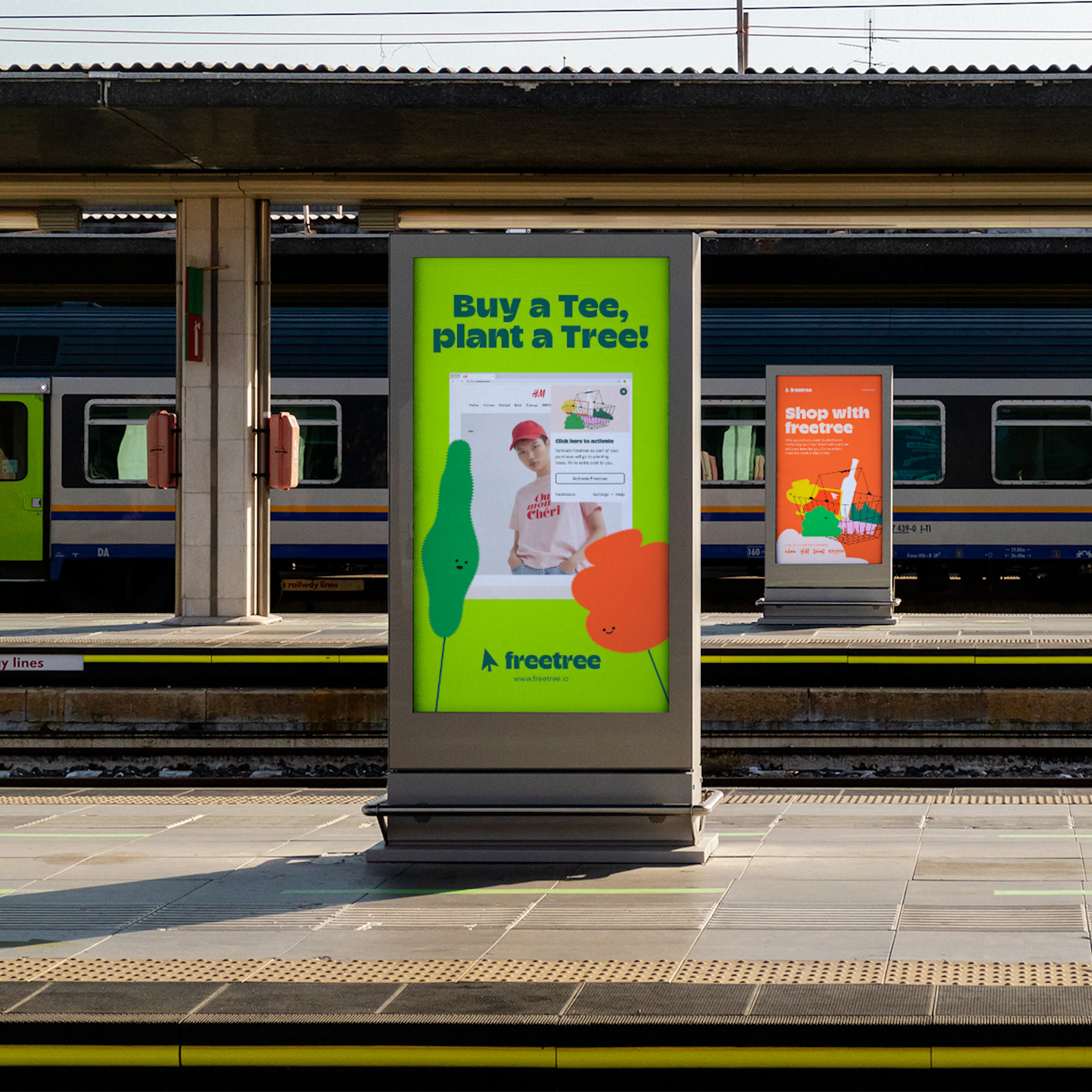 Freetree poster on a train station platform reading 'Buy a Tee, plant a Tree'