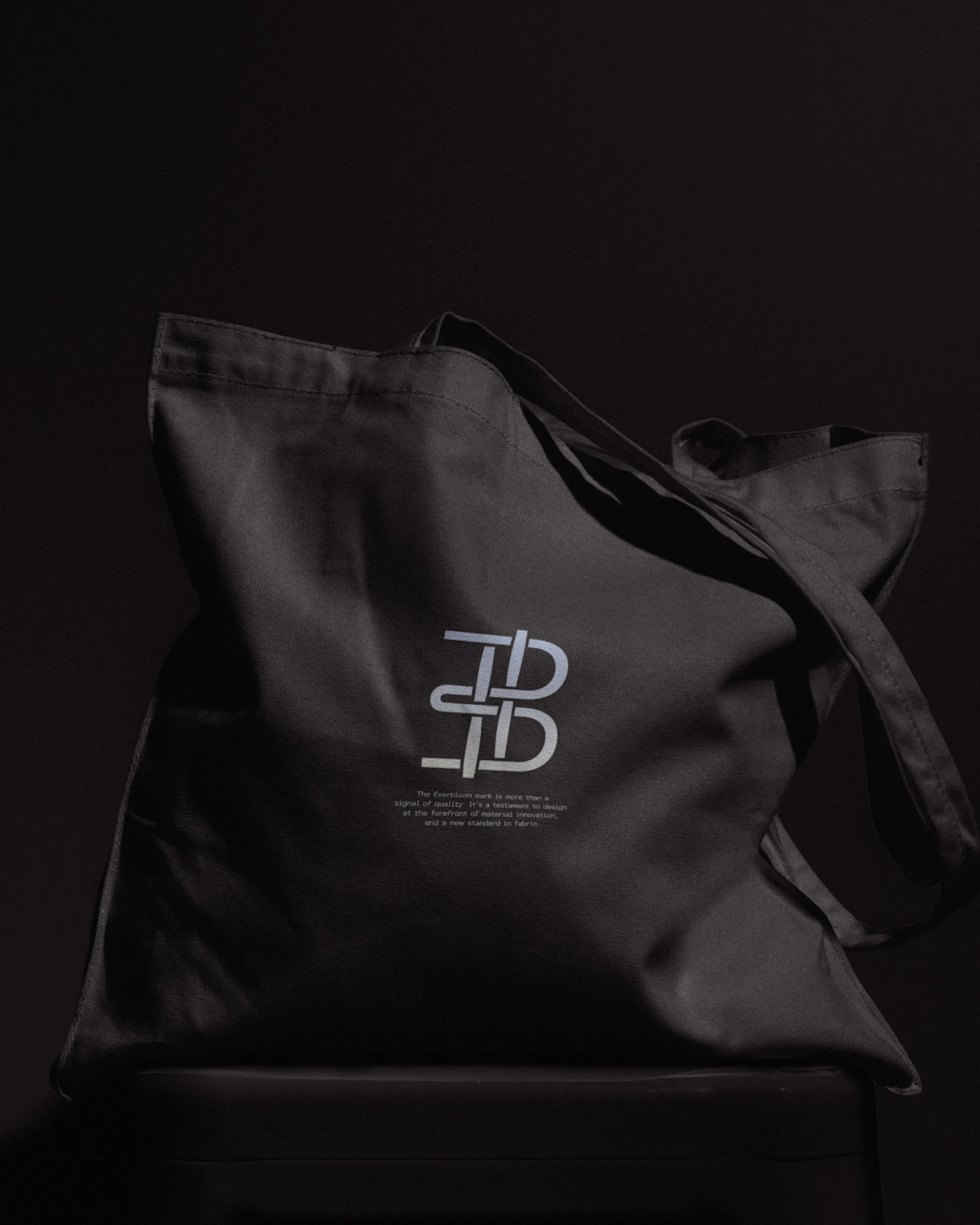 Black tote bag with the Everbloom monogram in white