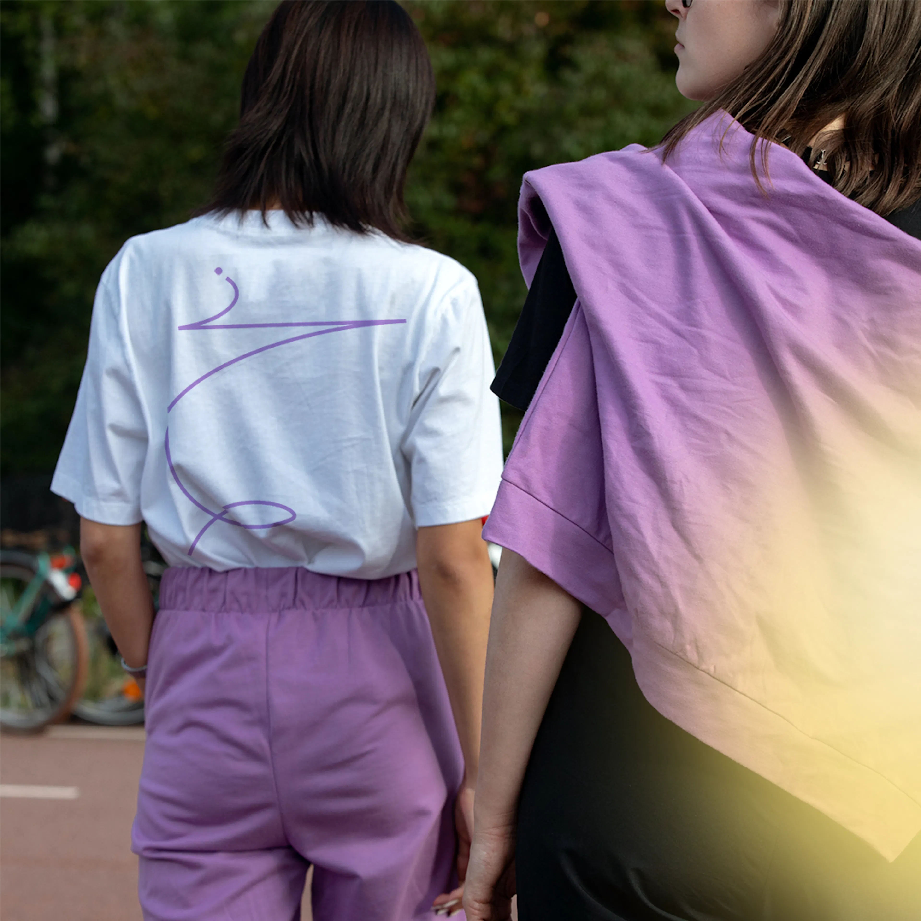 Two people walking away in Hotjar T-shirts, one with a line-drawn print on the back