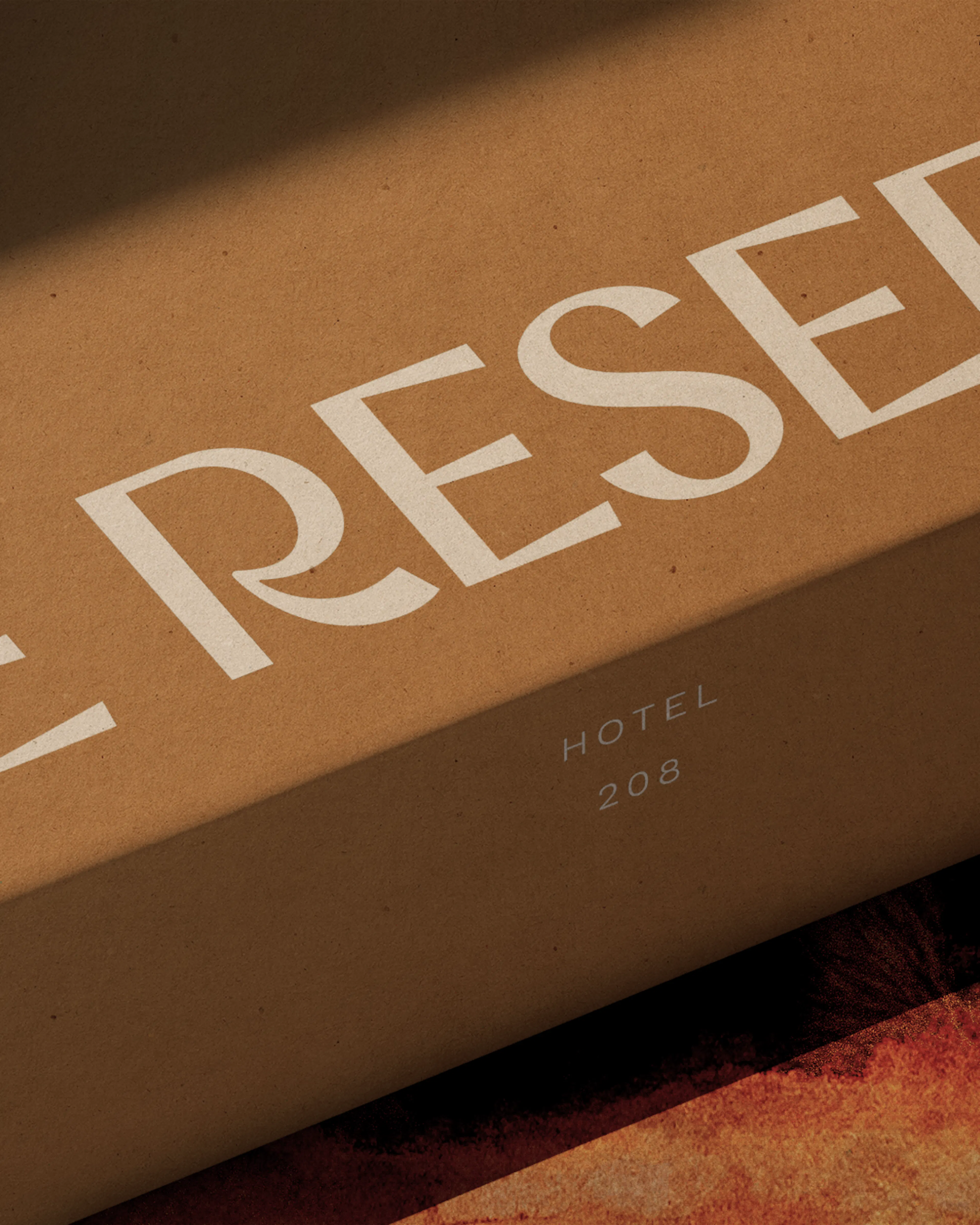 Close-up of a kraft welcome box printed with 'The Reserve' in cream lettering, resting on an animal-print surface