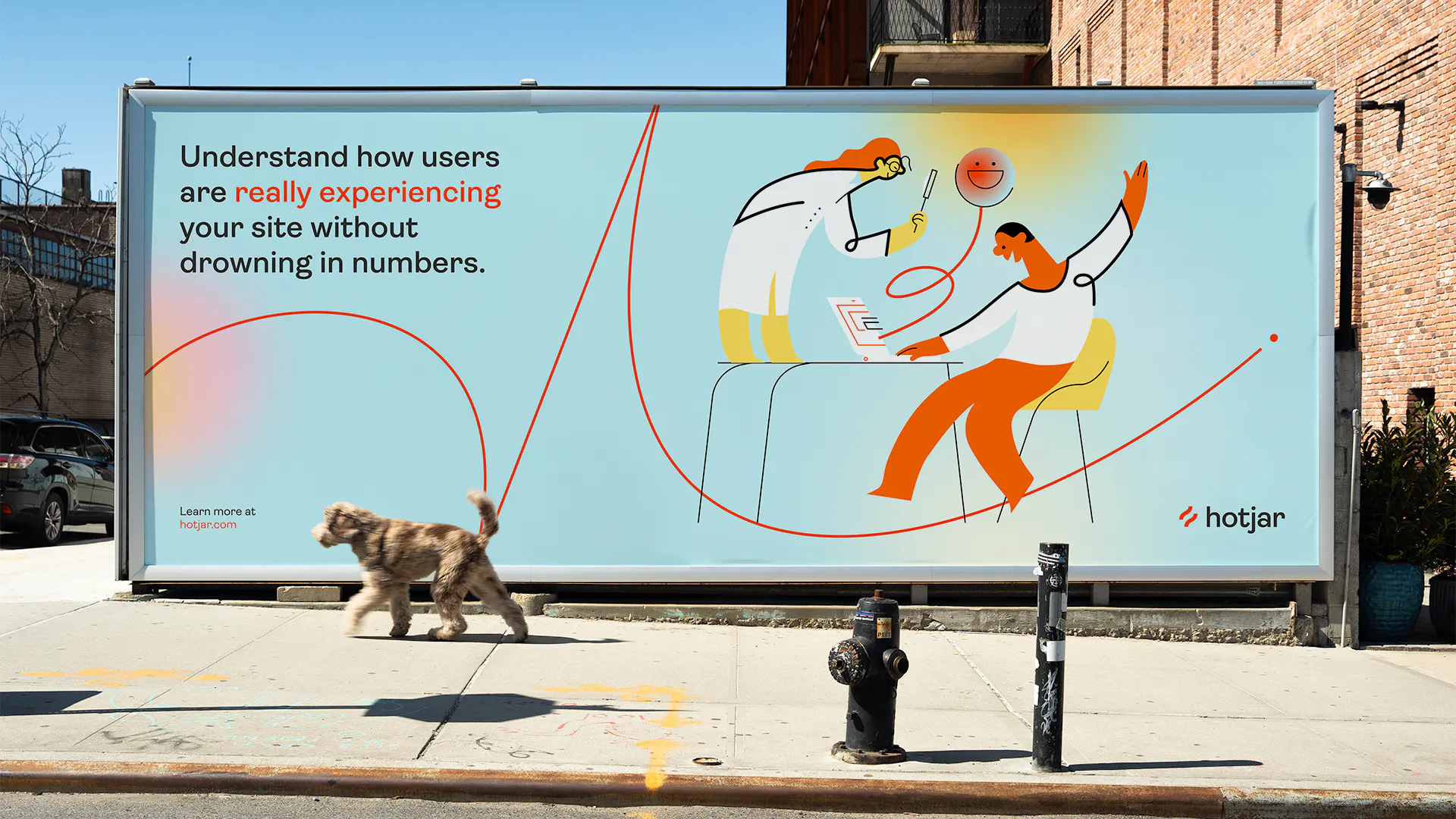 Hotjar billboard on a city street reading 'Understand how users are really experiencing your site without drowning in numbers', with a dog walking past