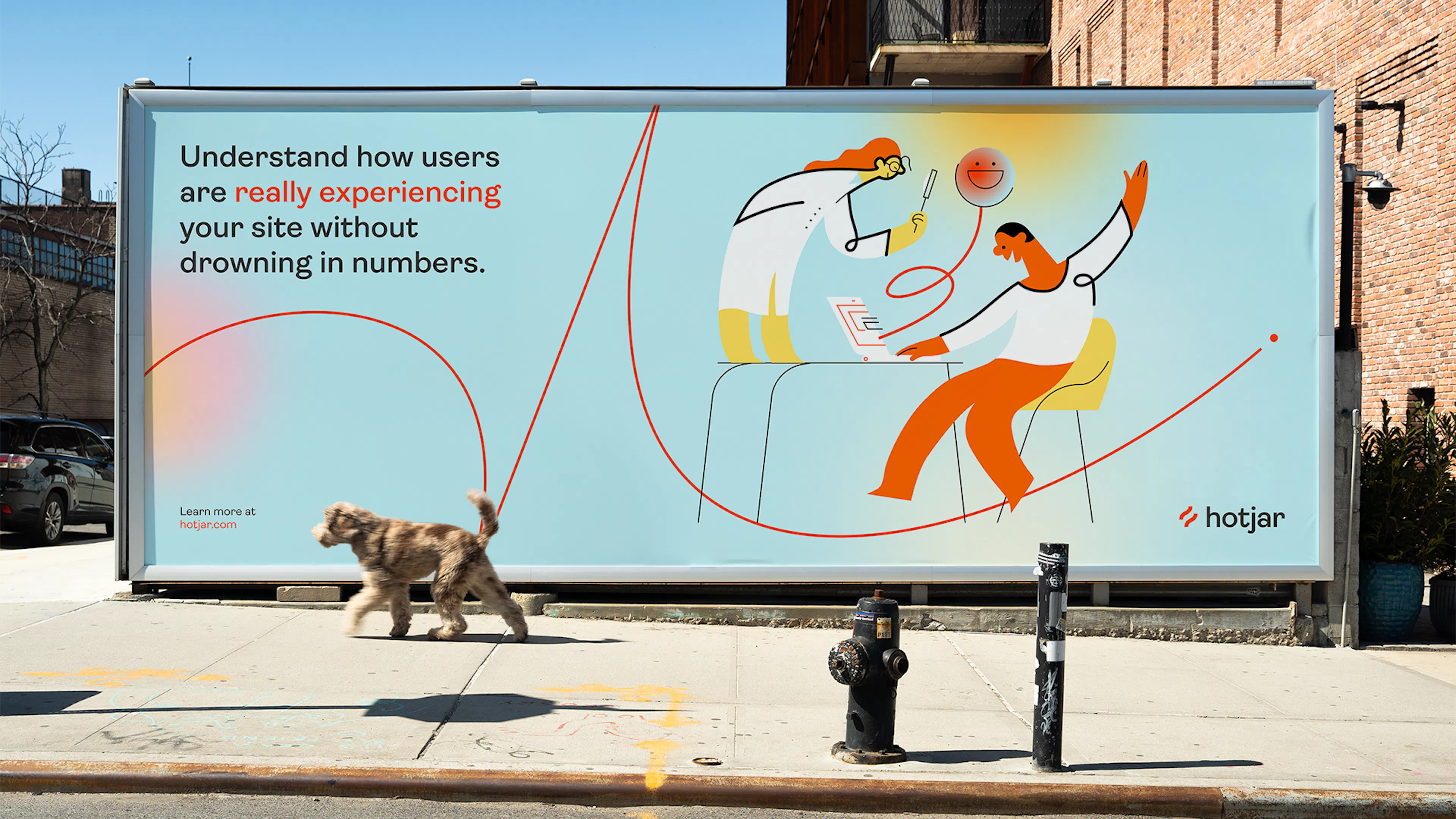 Hotjar billboard on a city street reading 'Understand how users are really experiencing your site without drowning in numbers', with a dog walking past