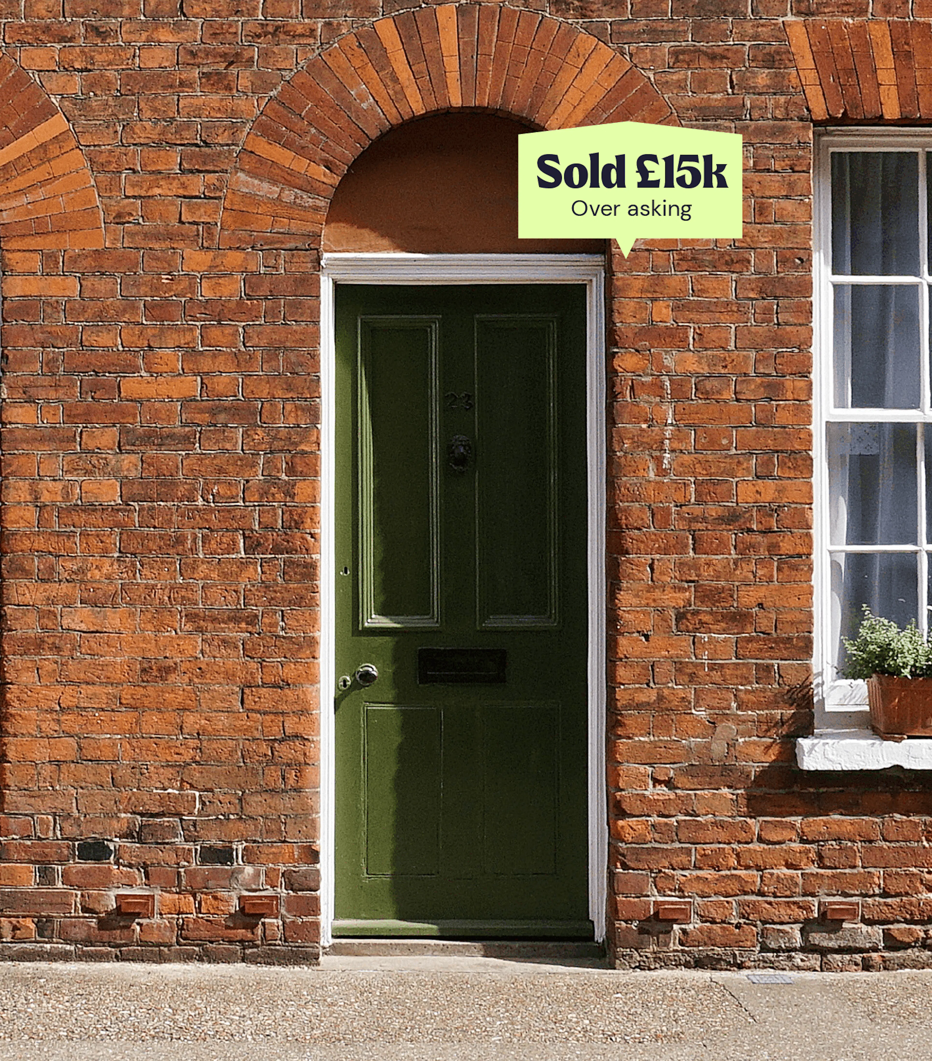 Brick house with a green front door and a lime flyp 'Sold' sign above it