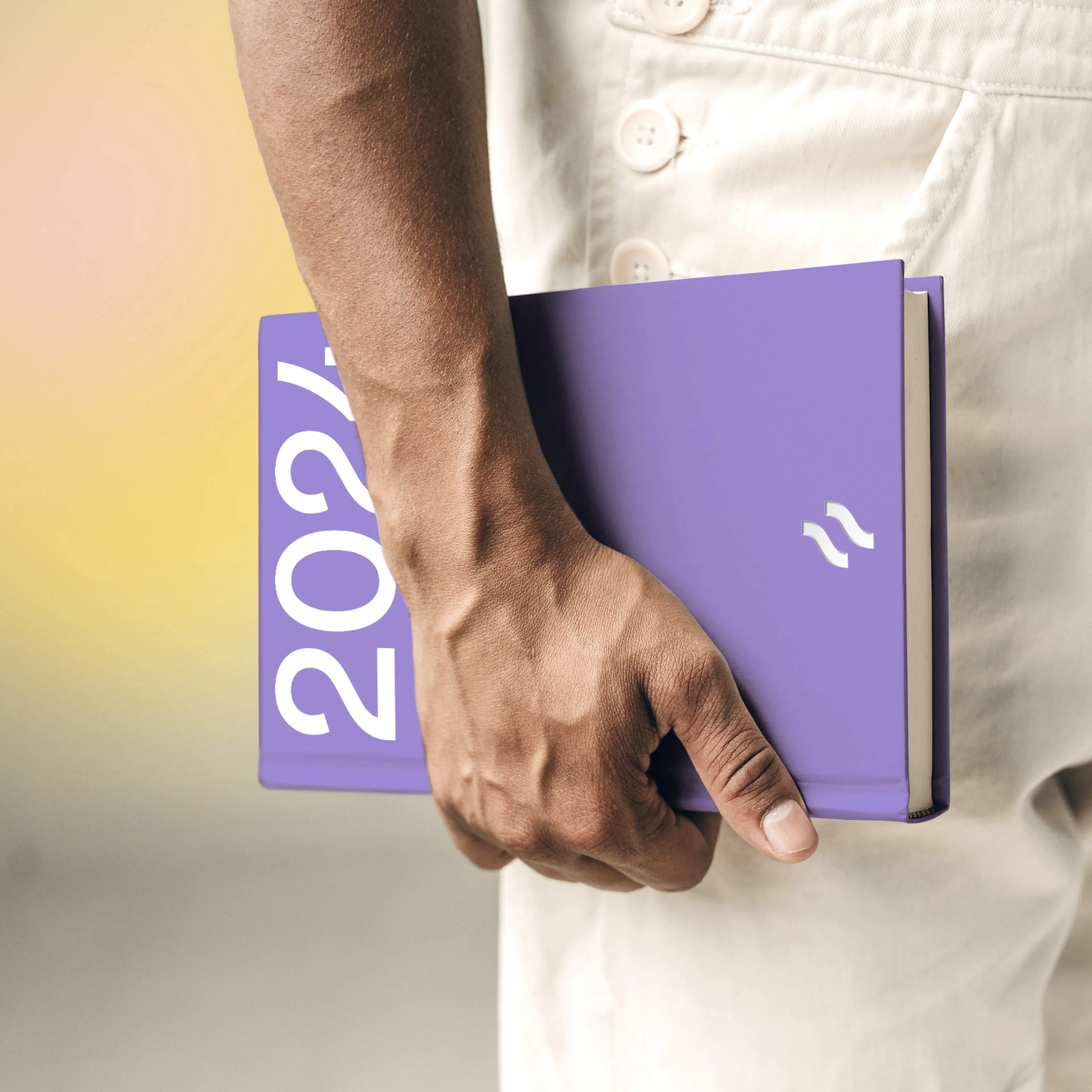 Person holding a lilac Hotjar 2024 notebook at their side