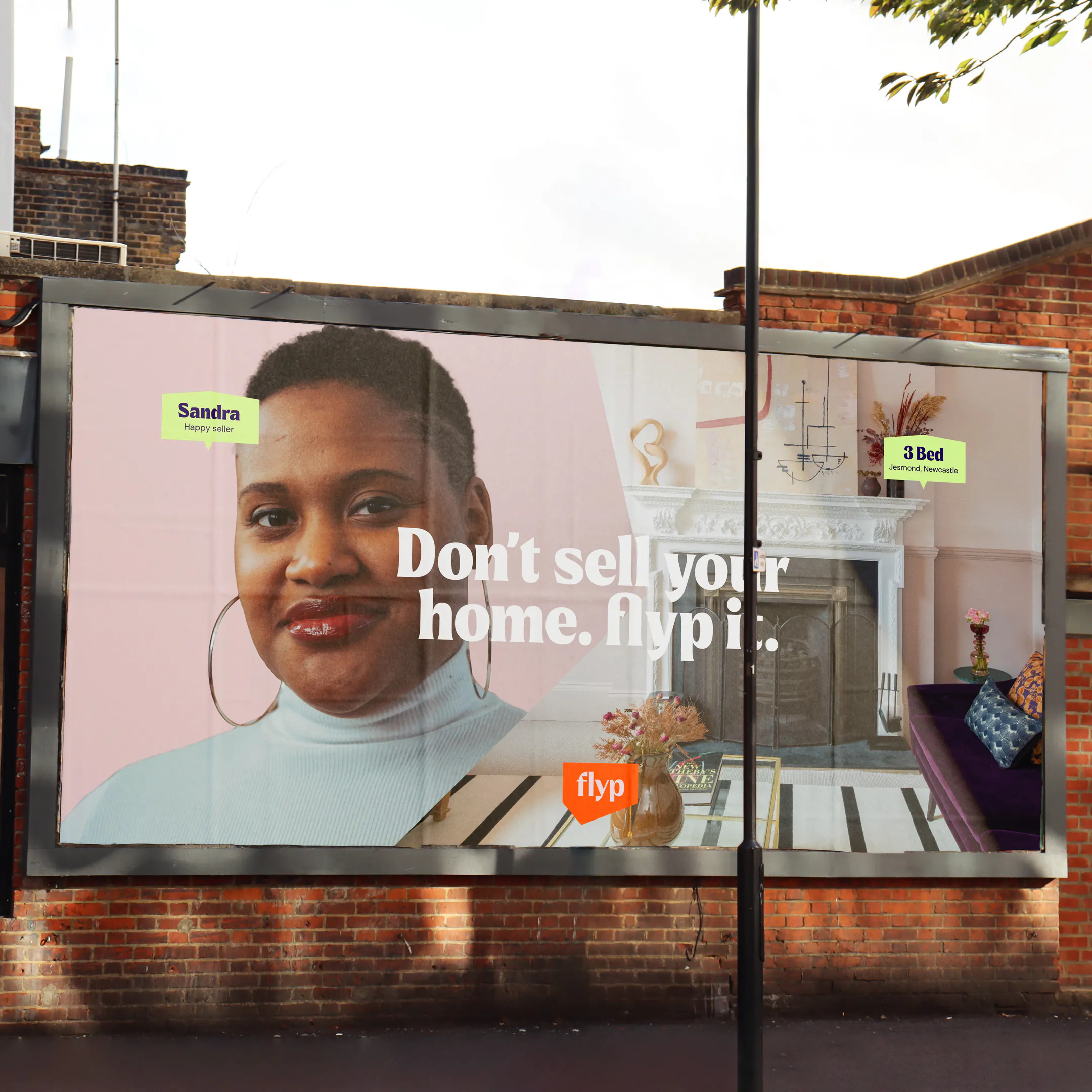 Roadside billboard reading 'Don't sell your home. flyp it.' with a portrait of a man beside a living room