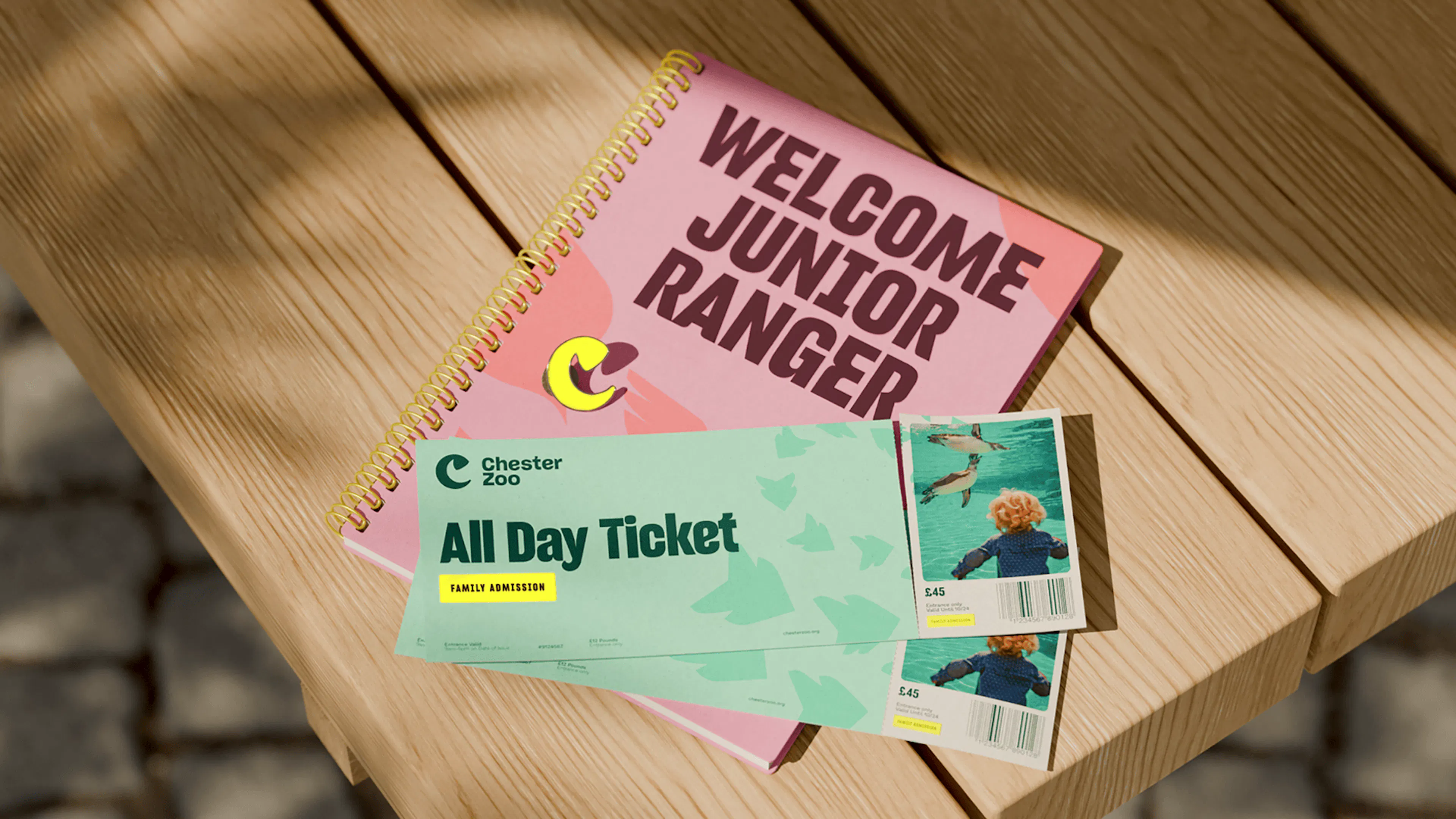 Chester Zoo All Day Ticket and 'Welcome Junior Ranger' notebook on a picnic table