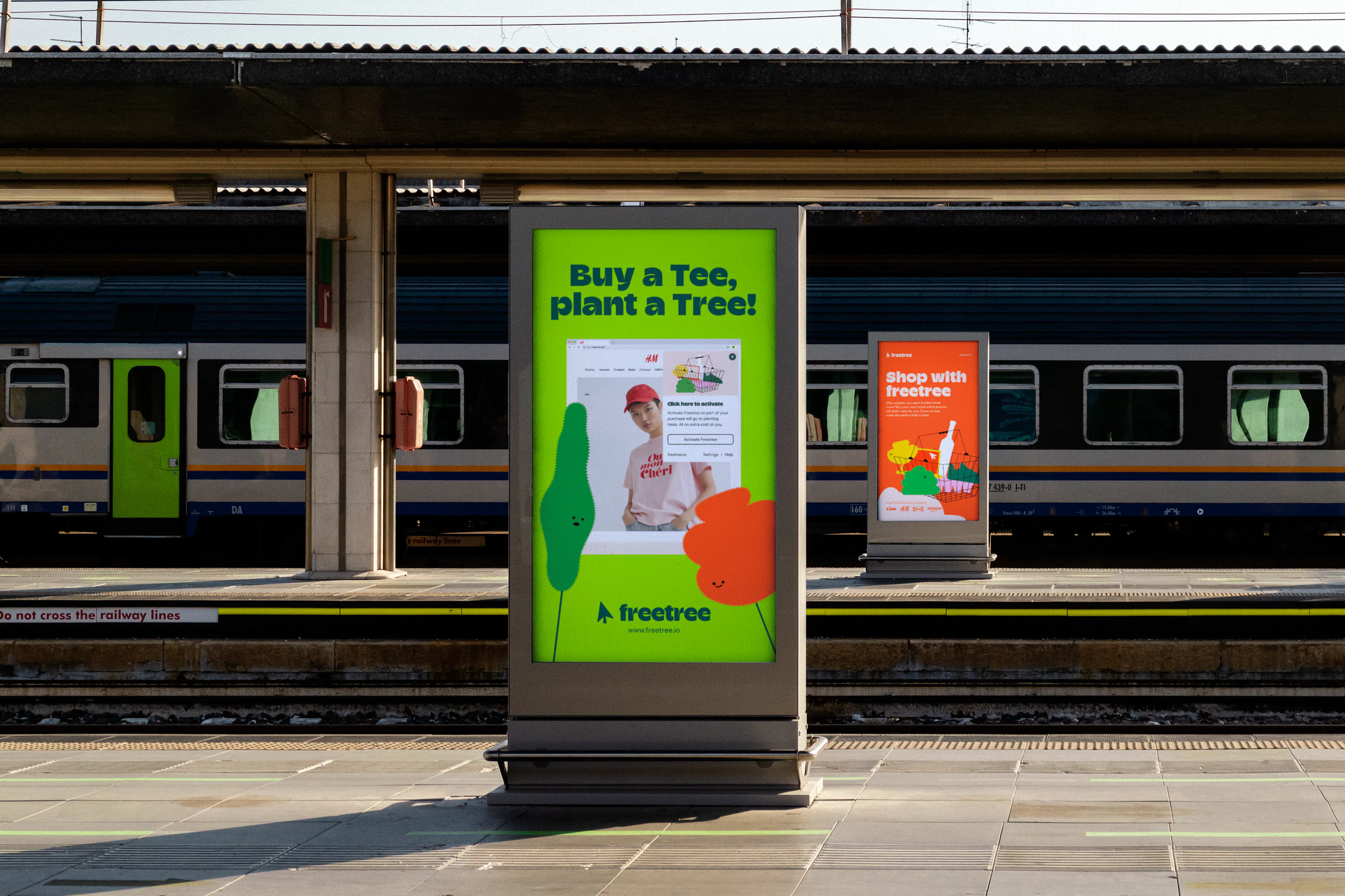 Freetree poster on a train station platform reading 'Buy a Tee, plant a Tree'