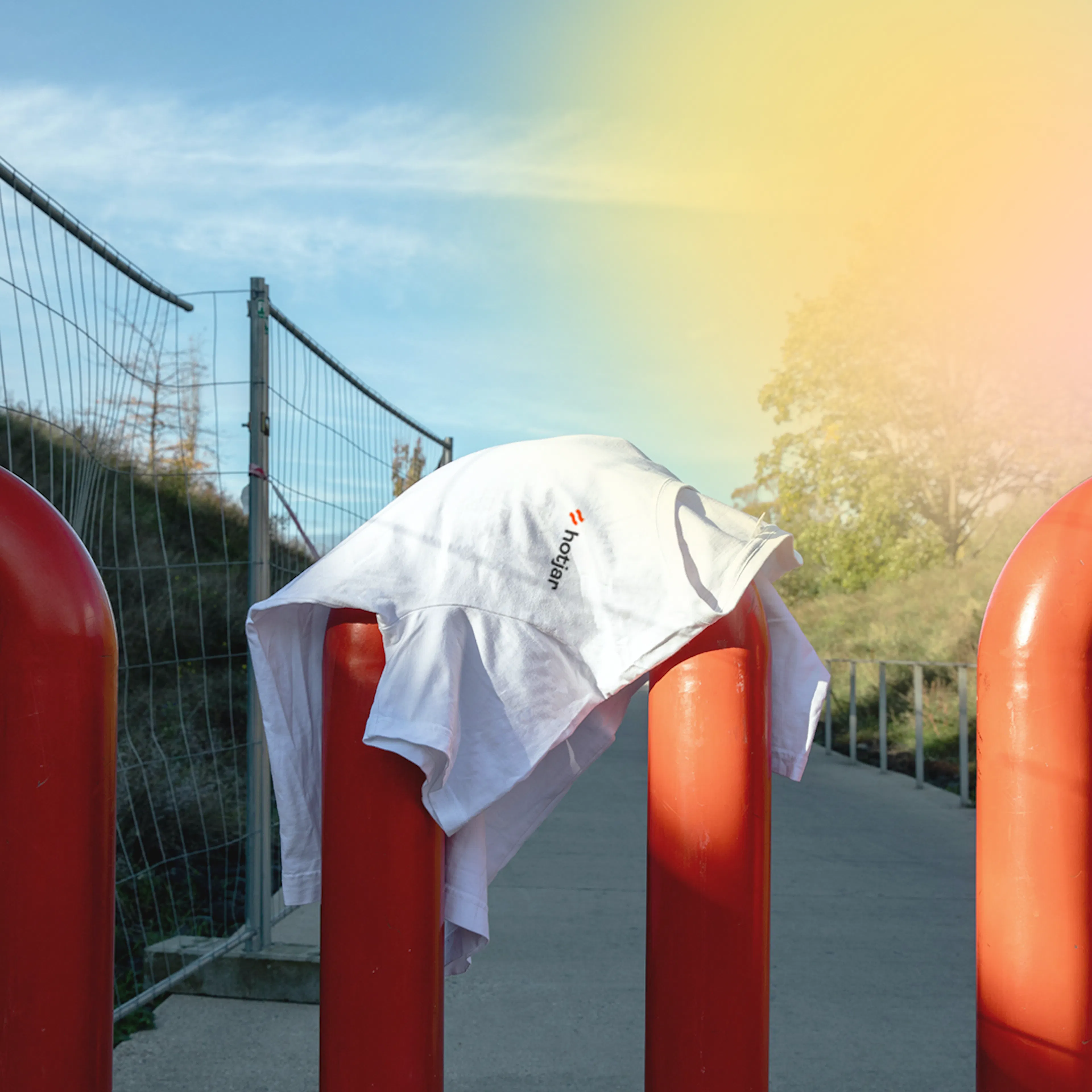 White Hotjar T-shirt draped over red bollards in the sunshine