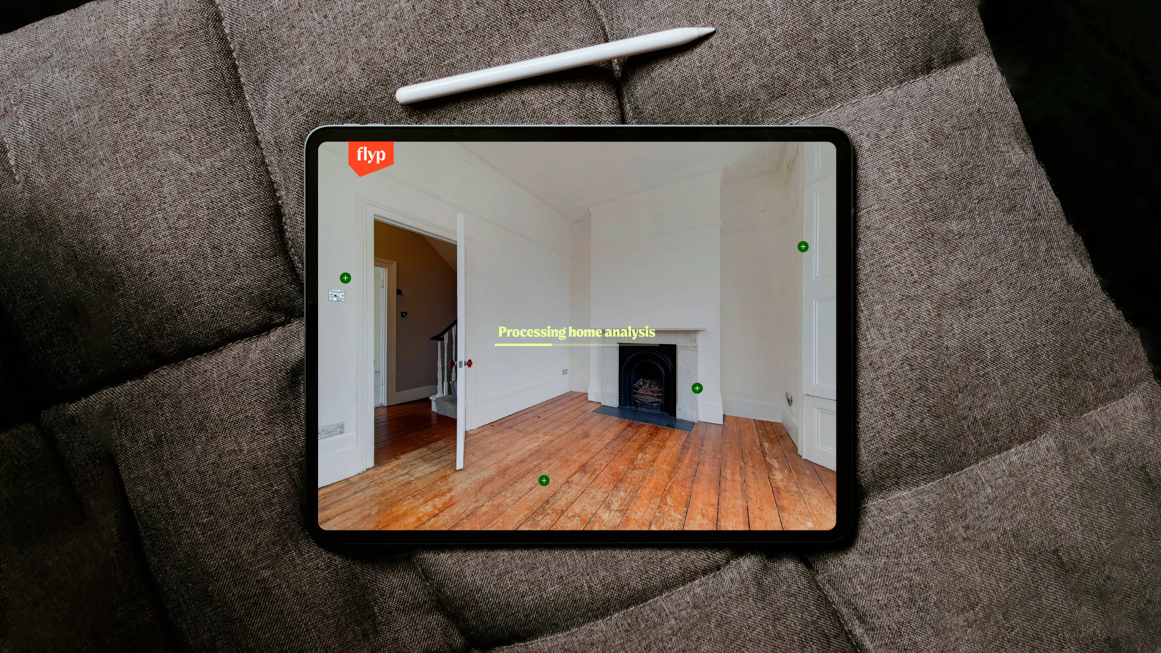 Tablet on a grey cushion showing a flyp analysis of an empty white room