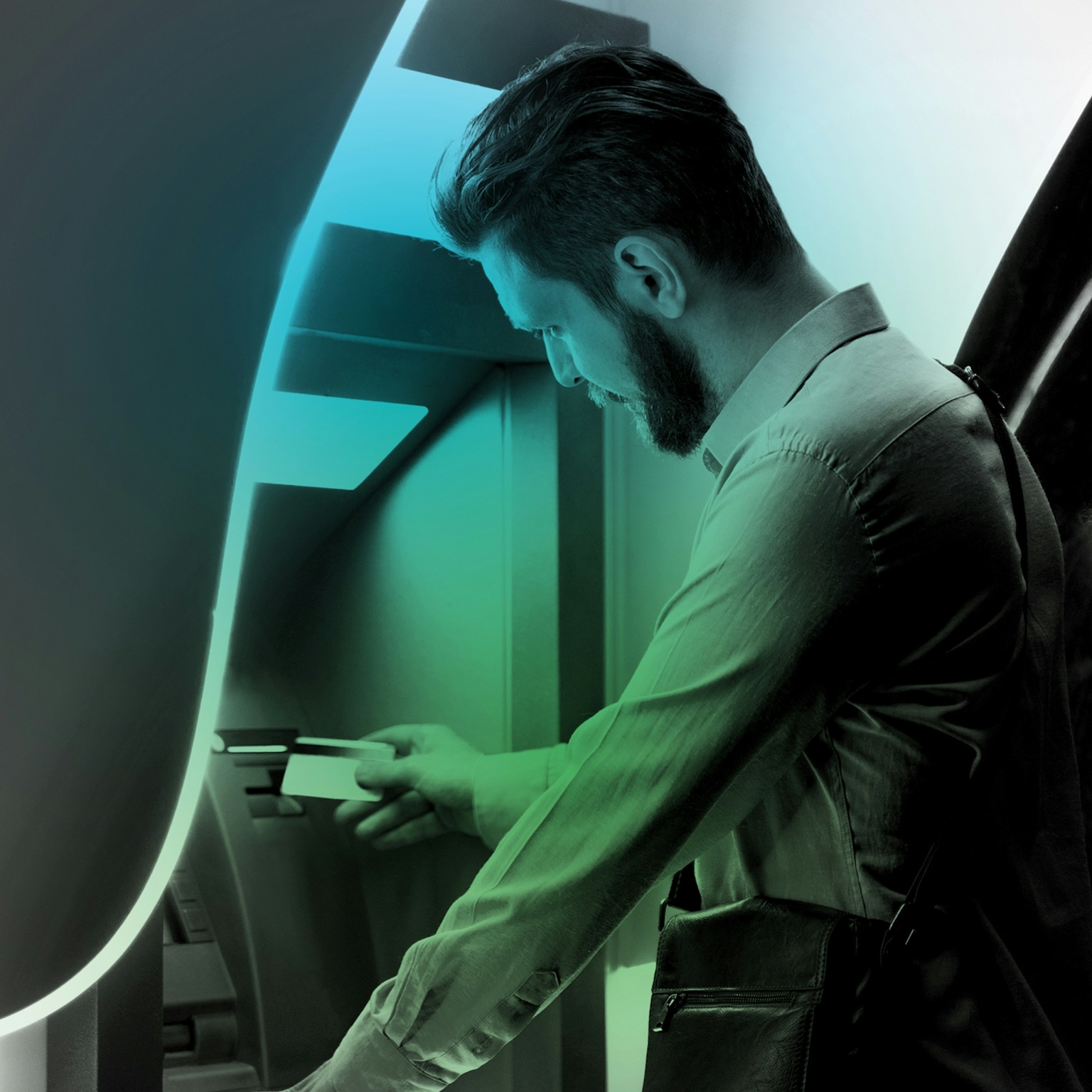 Un homme à un distributeur de billets retirant de l'argent.