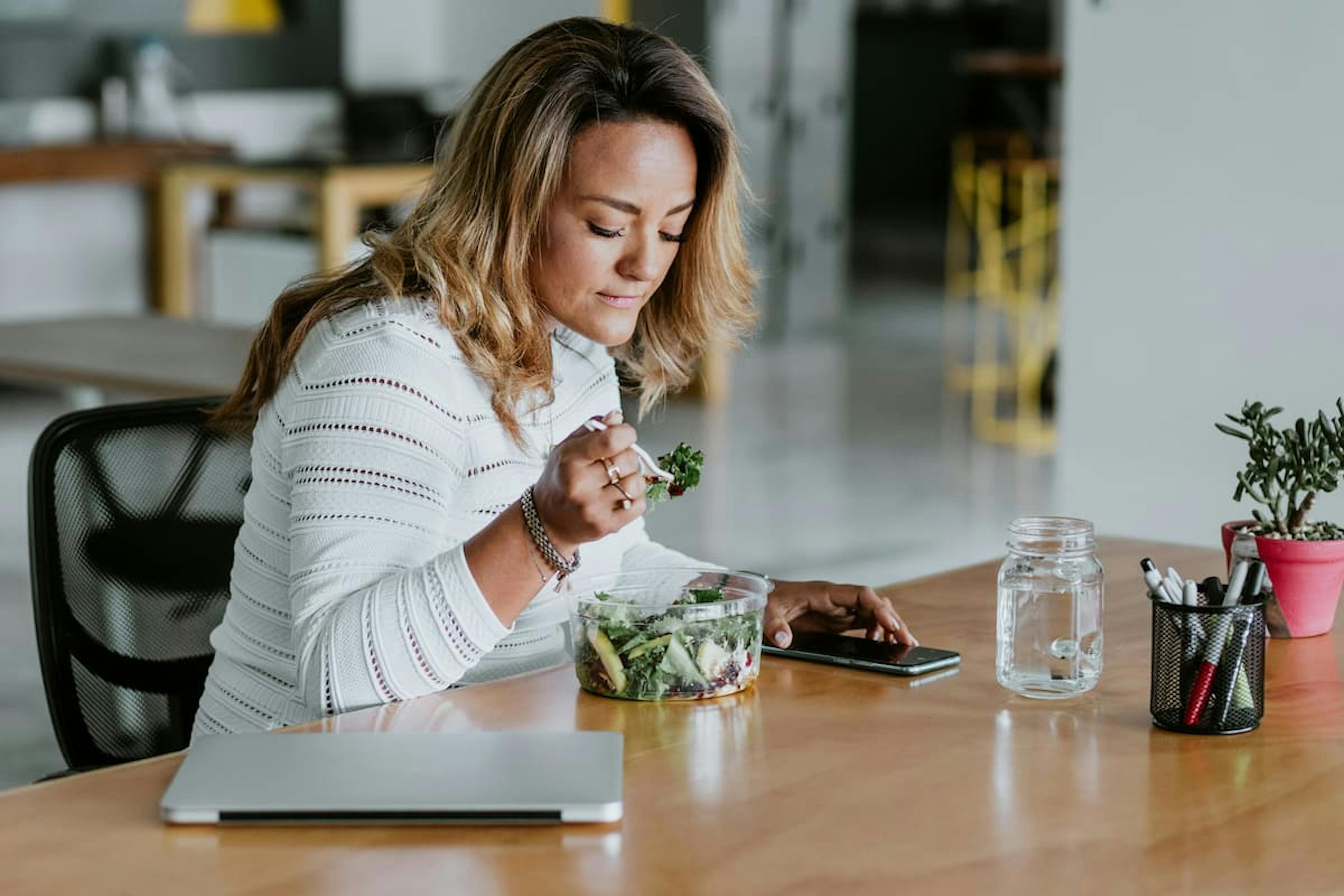 woman eating salad at work