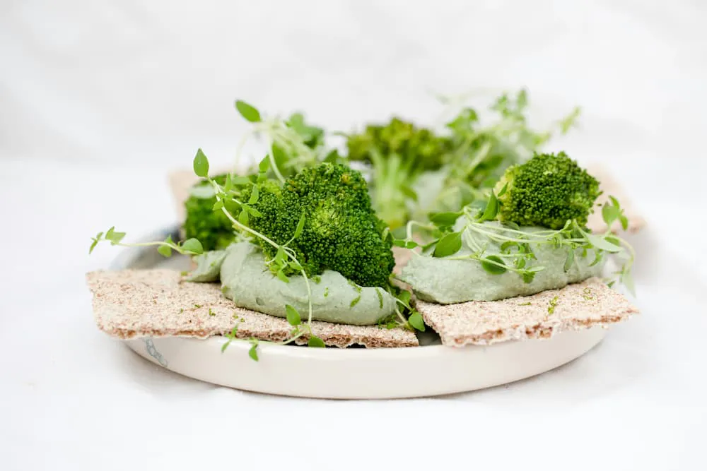 Healthy dish with broccoli, green pasta, and fresh herbs