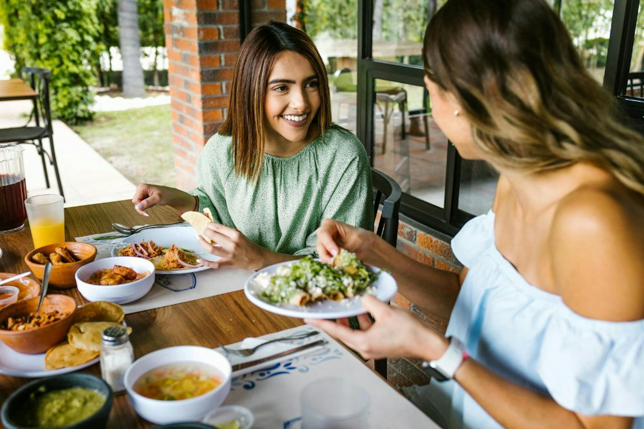 Two happy women enjoying a meal with tacos in a cozy setting