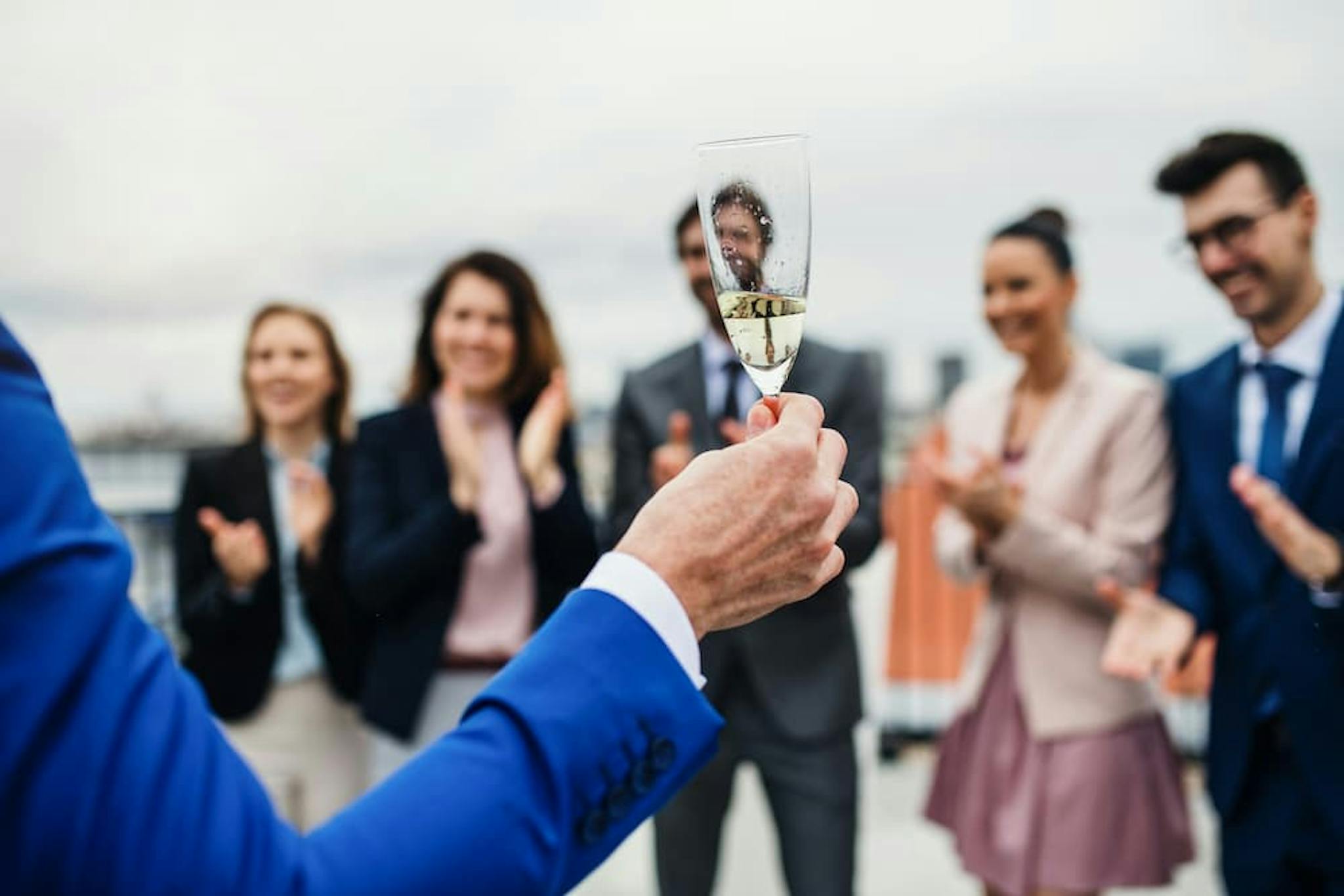 A group of people celebrating with champagne glasses at a social event, conveying joy and camaraderie in a festive environment