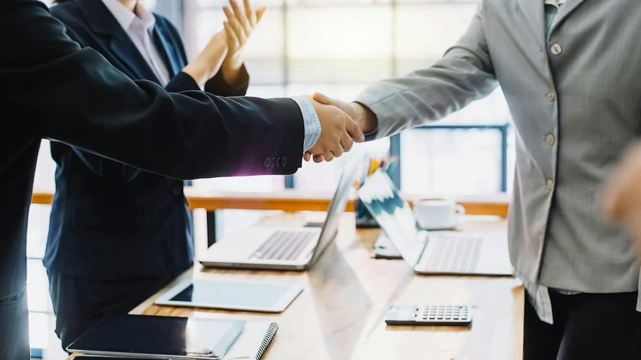 Handshake between professionals in a modern office environment.