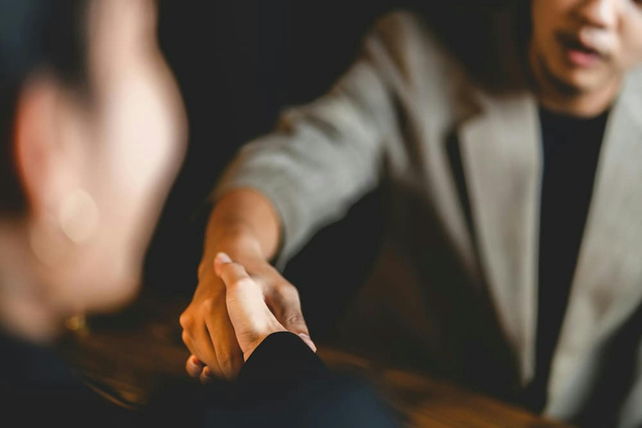 Two people shaking hands in a professional environment.