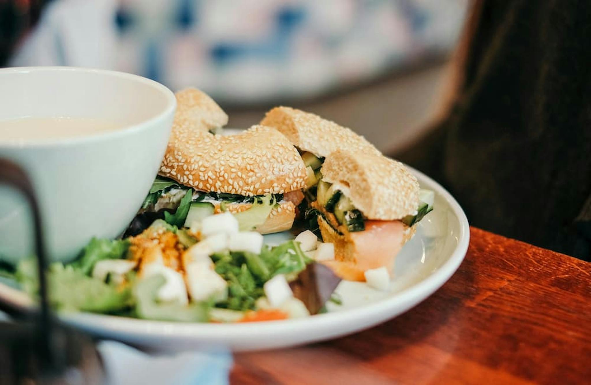 A plate with sesame bagels and a fresh salad on the side.