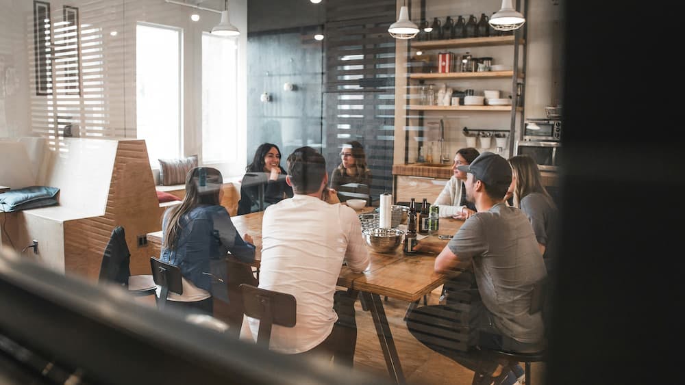 Group of people in a collaborative meeting in a modern office environment, discussing ideas around a table