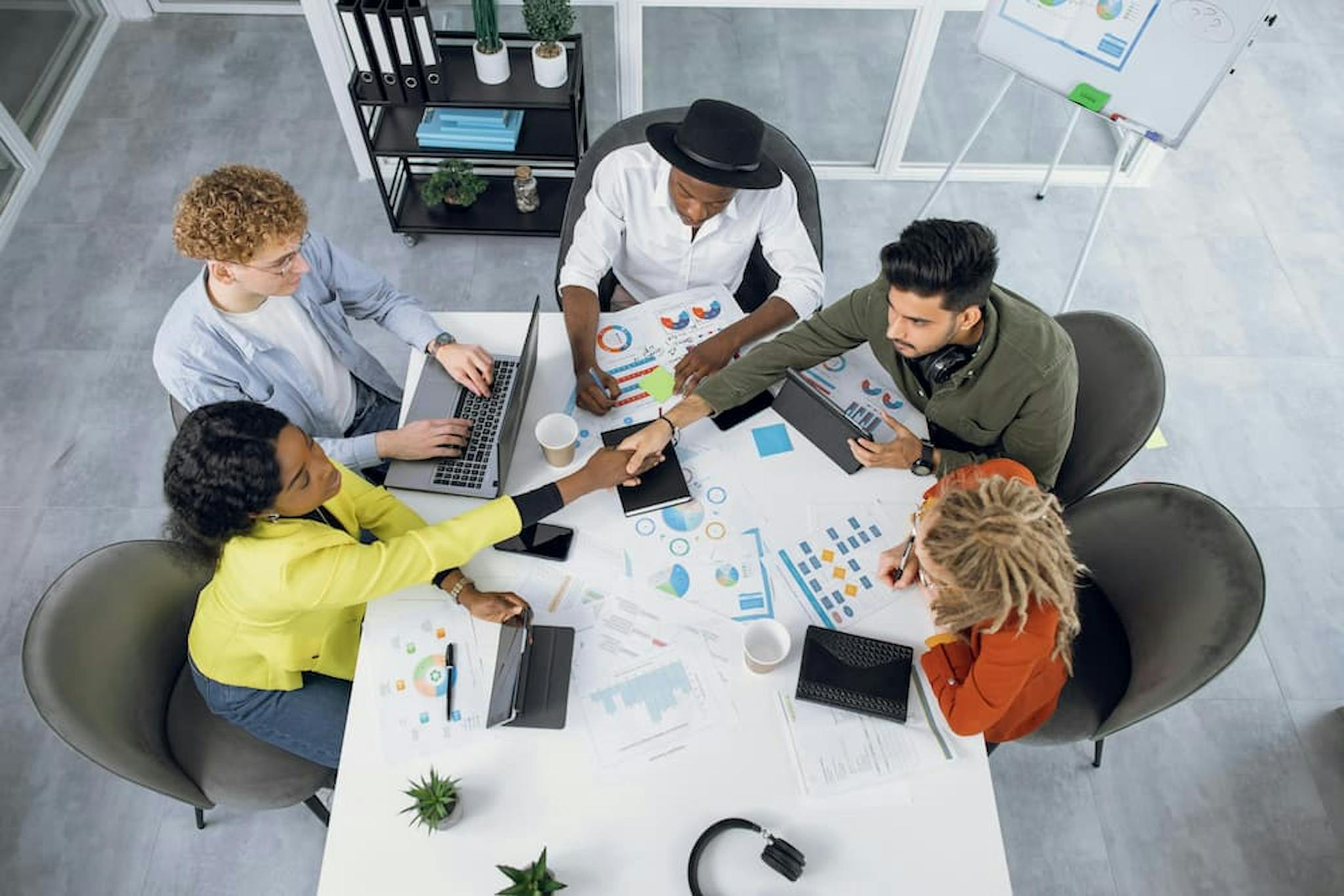 Group of people working as a team in a meeting, analyzing charts and exchanging ideas