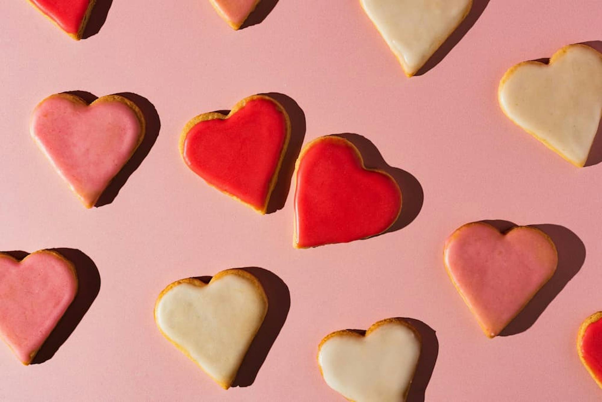 Delicious heart-shaped cookies decorated with colorful icing in shades of red and pink.