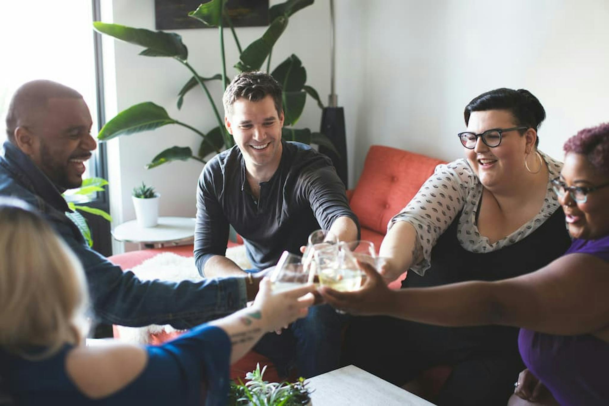 Group of colleagues having fun in a meeting, toasting with glasses.