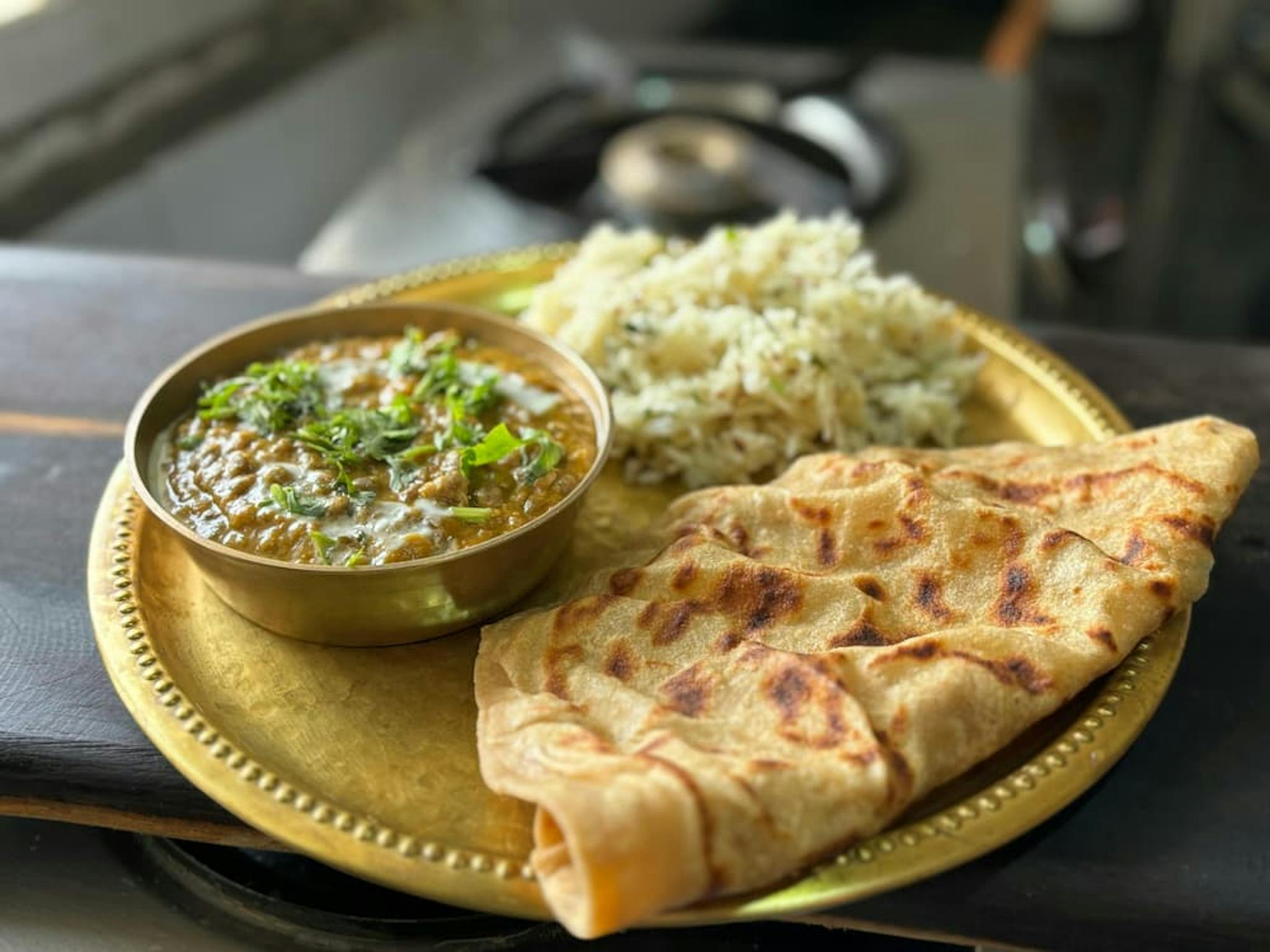 Plate of Indian food with curry, rice, and naan.