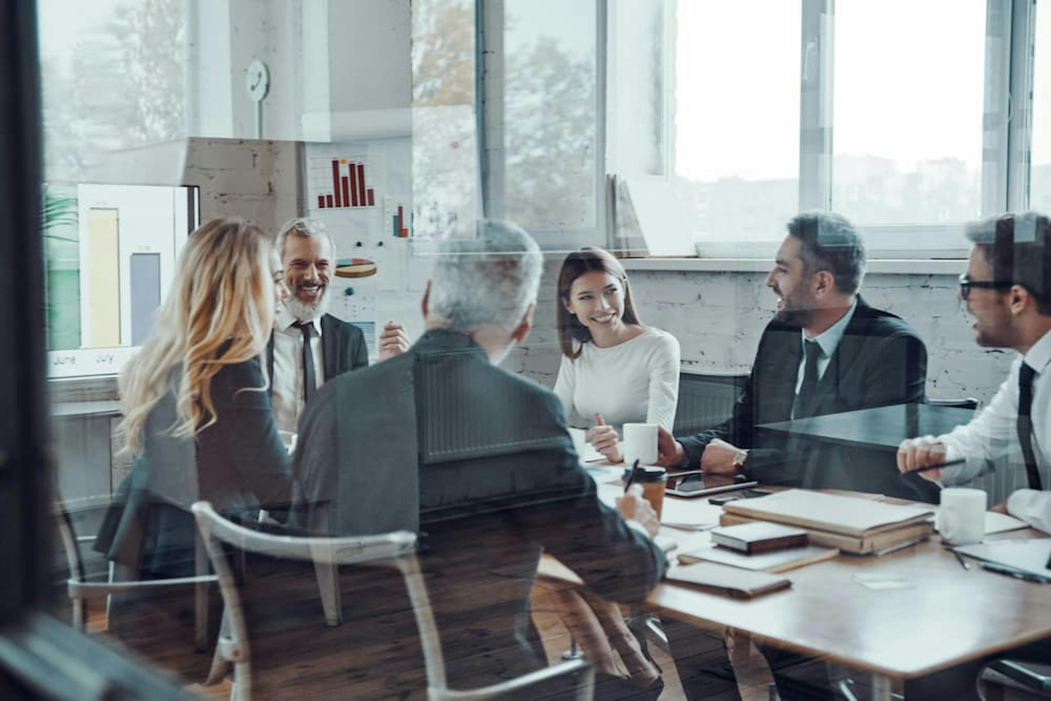 Business meeting in a modern environment with professionals discussing strategies, charts, and results.